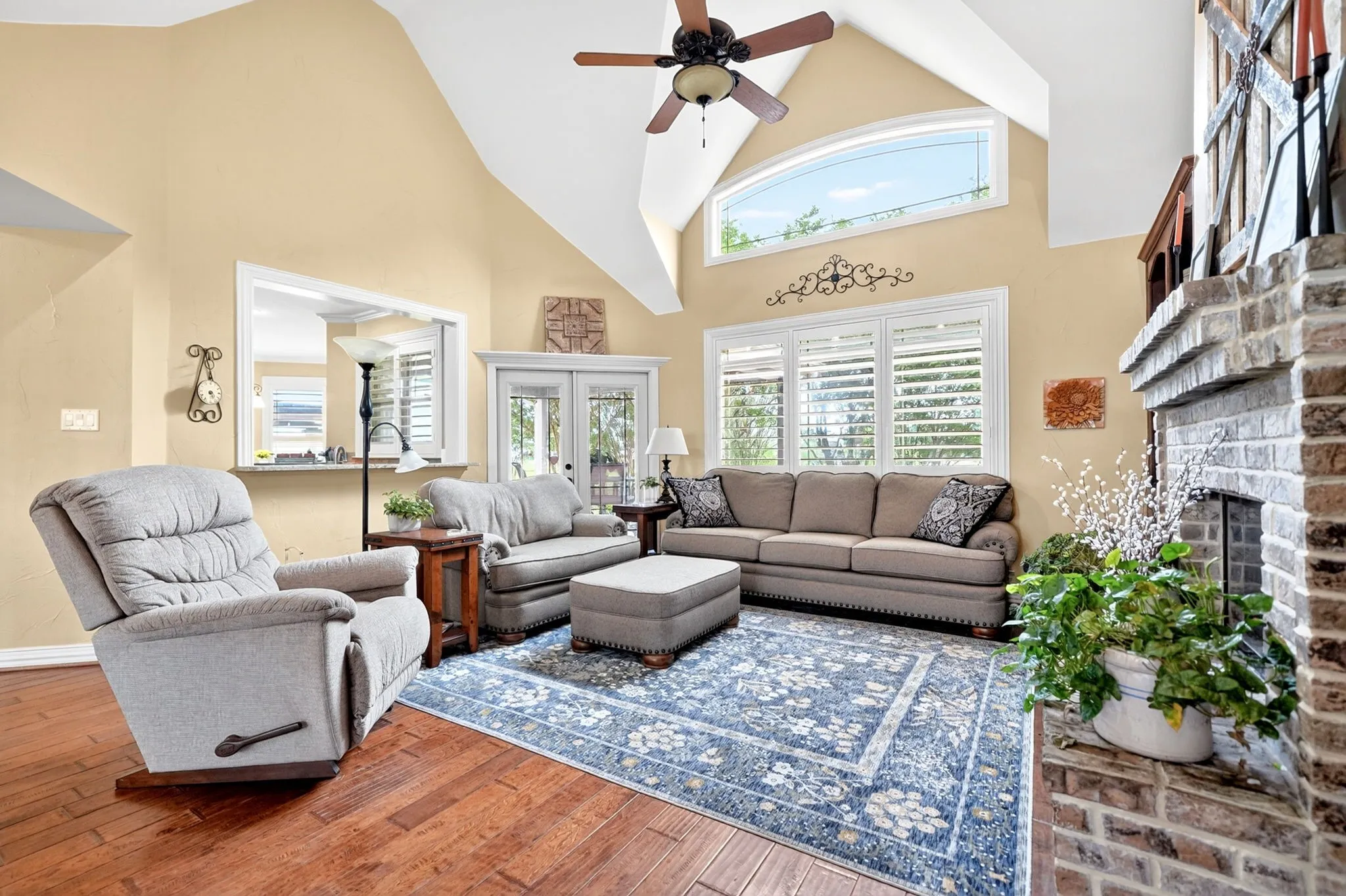 Living area featuring wood-finish flooring and a vaulted ceiling with a ceiling fan