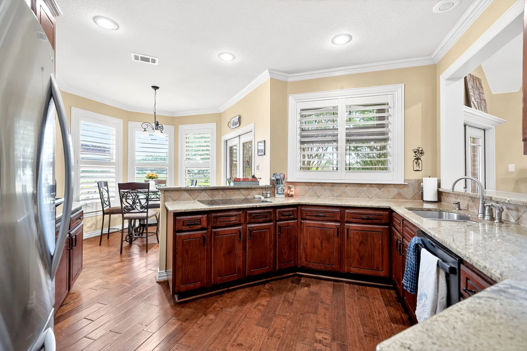 Kitchen featuring wood-finish flooring, recessed lighting, and a breakfast bar with stone countertops