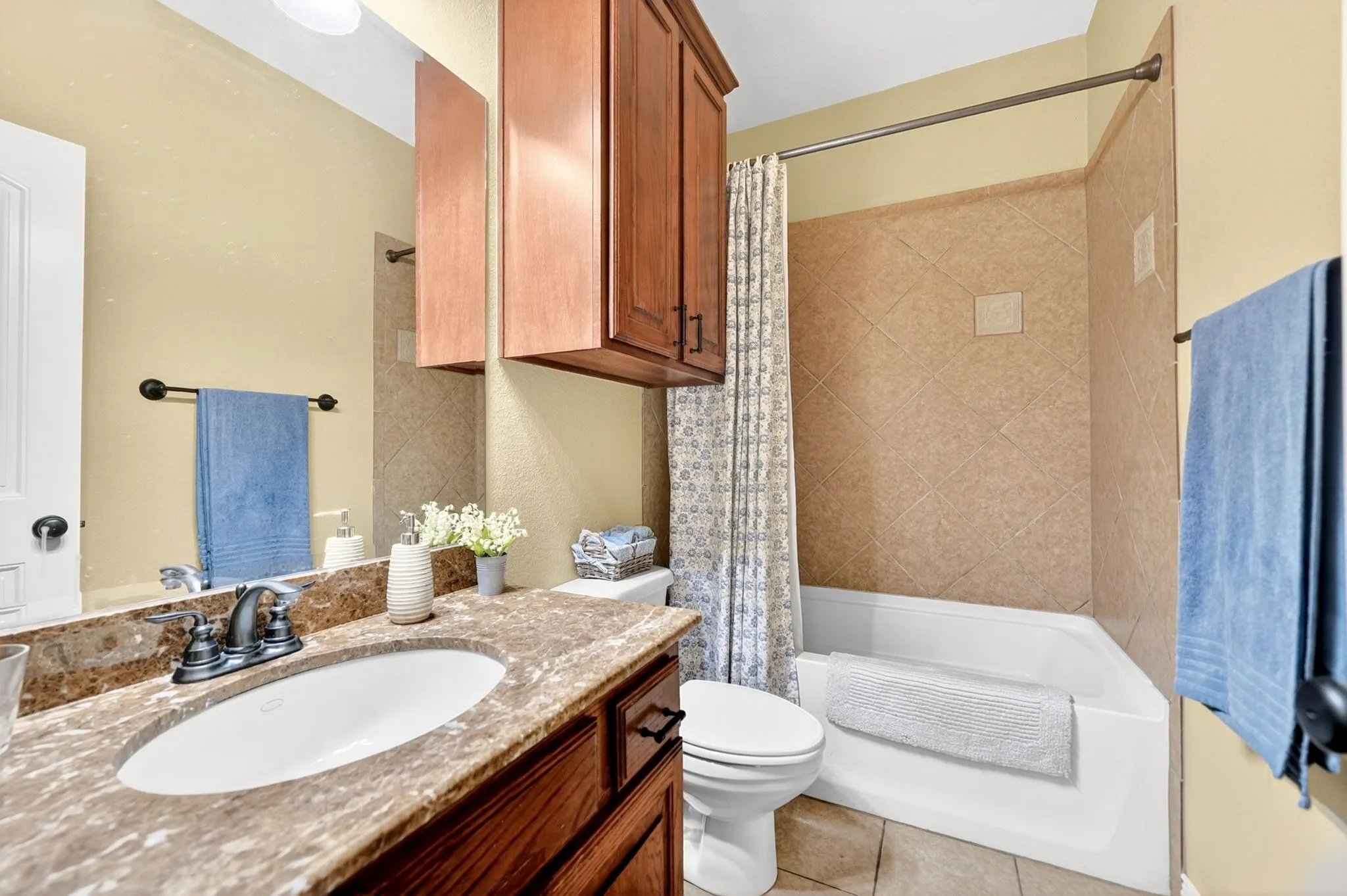 Bathroom featuring a vanity with an undermount sink, a stone-finish countertop, and dark wood cabinetry