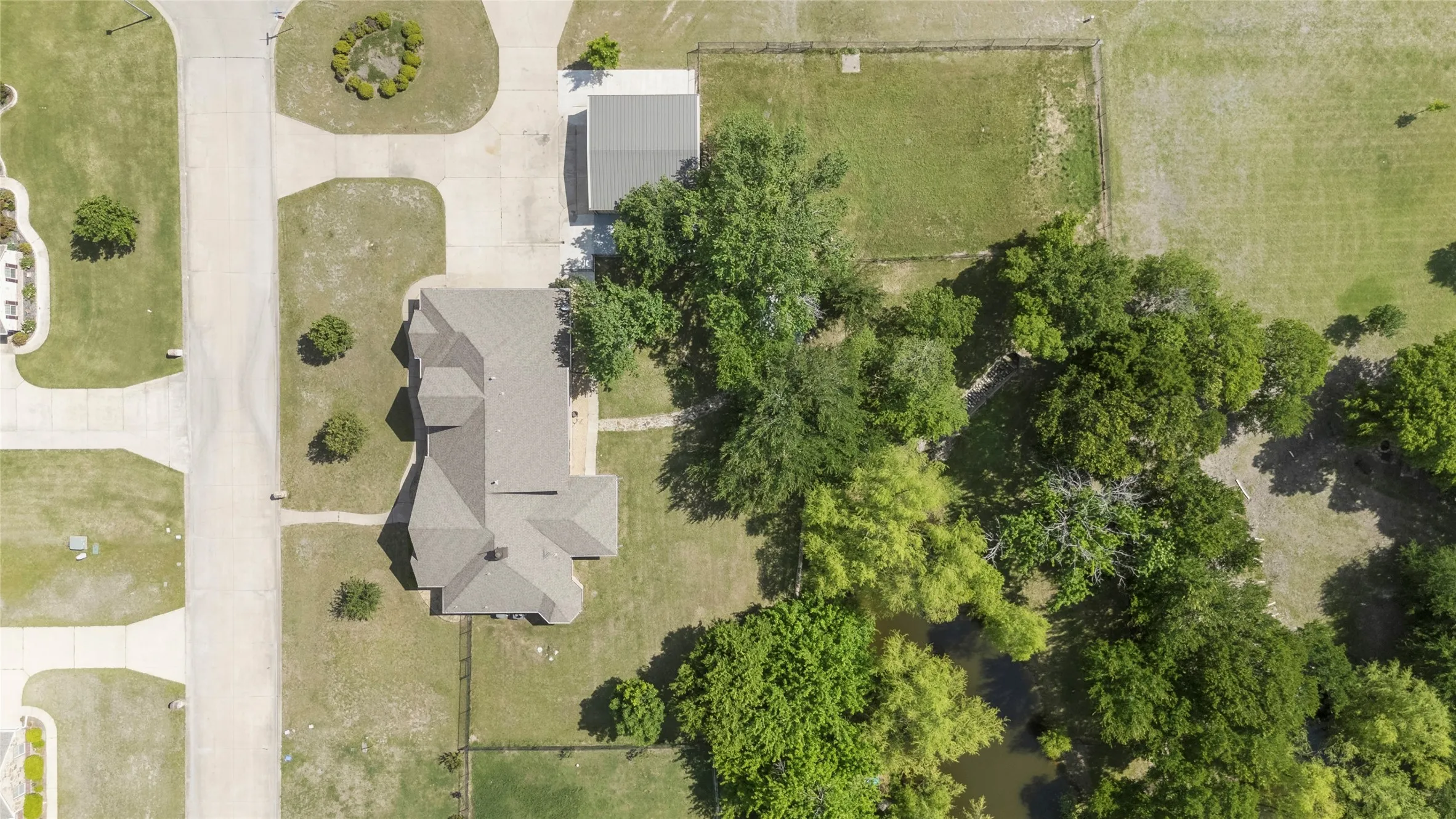 Property featuring a multi-gabled roofline, an attached paved driveway, and an additional detached structure