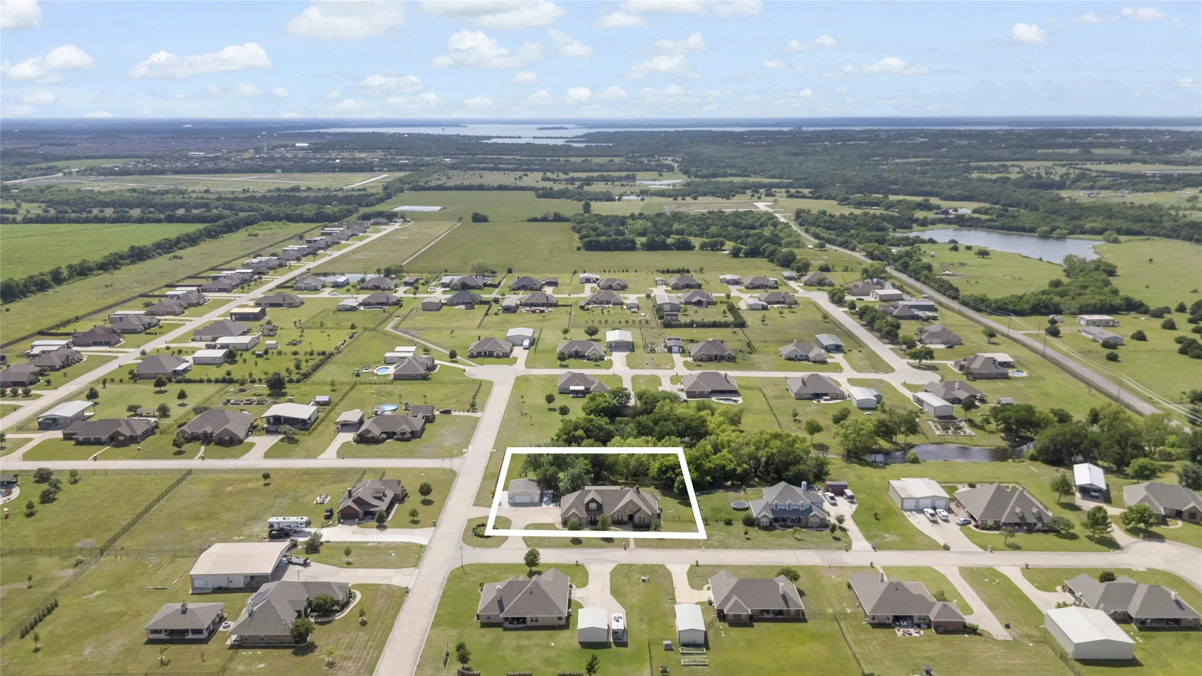 Aerial perspective showcasing the property within a residential neighborhood with surrounding green spaces