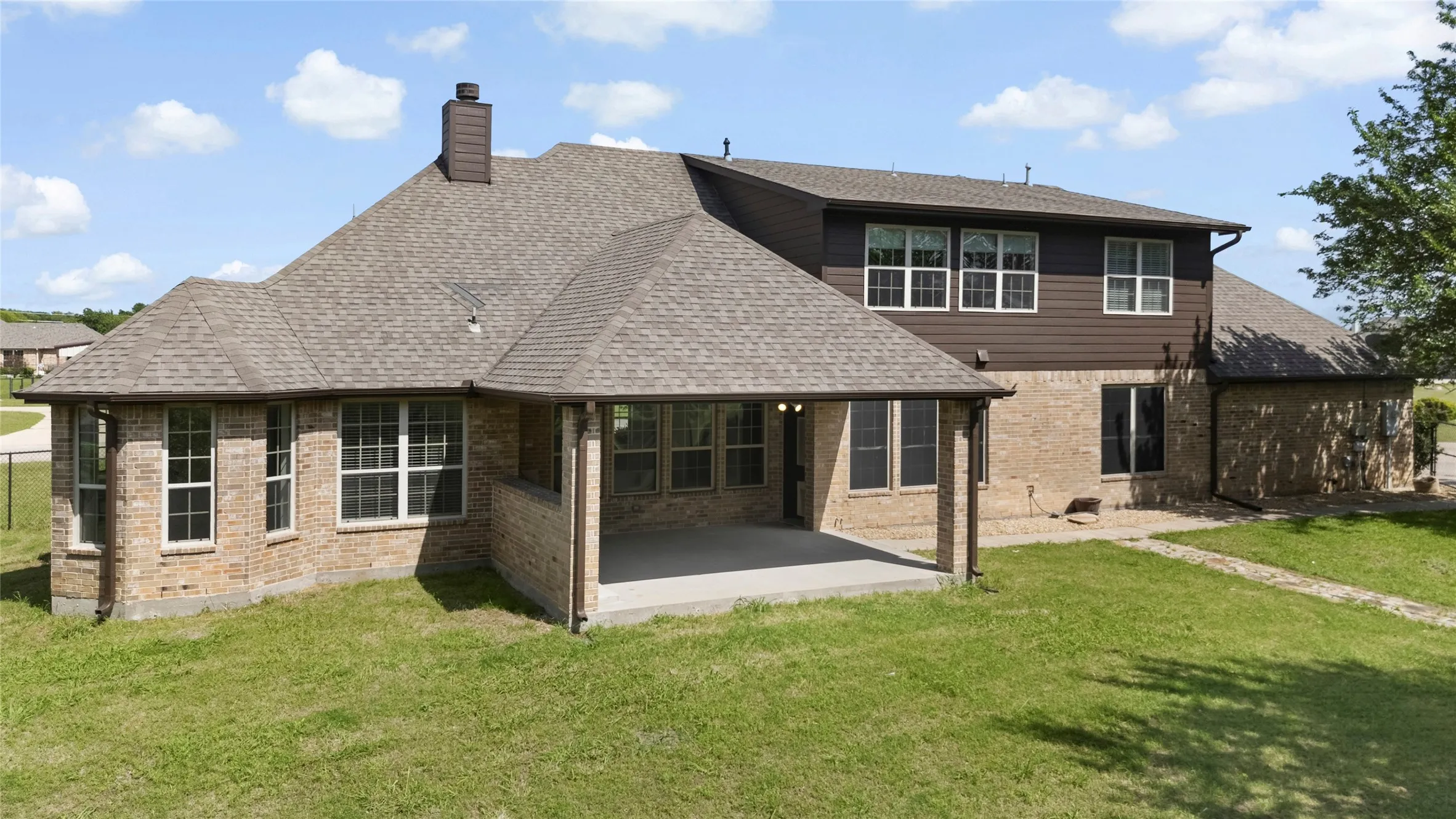 Brick and siding exterior featuring a covered concrete patio
