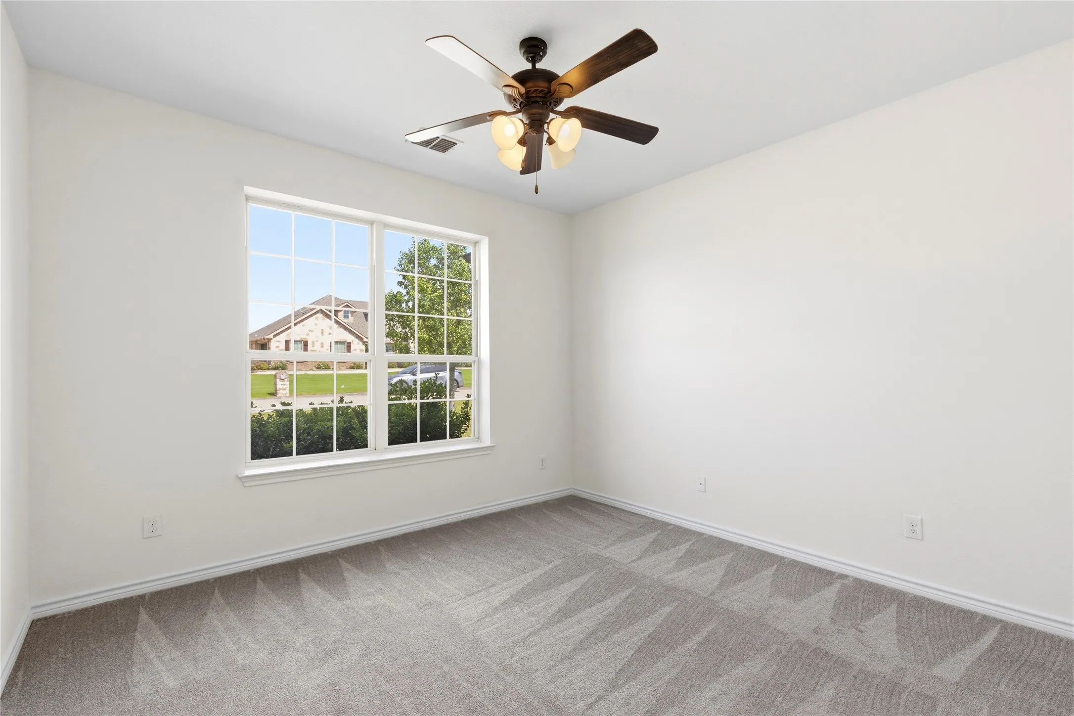 Bright interior room with a large window overlooking the neighborhood