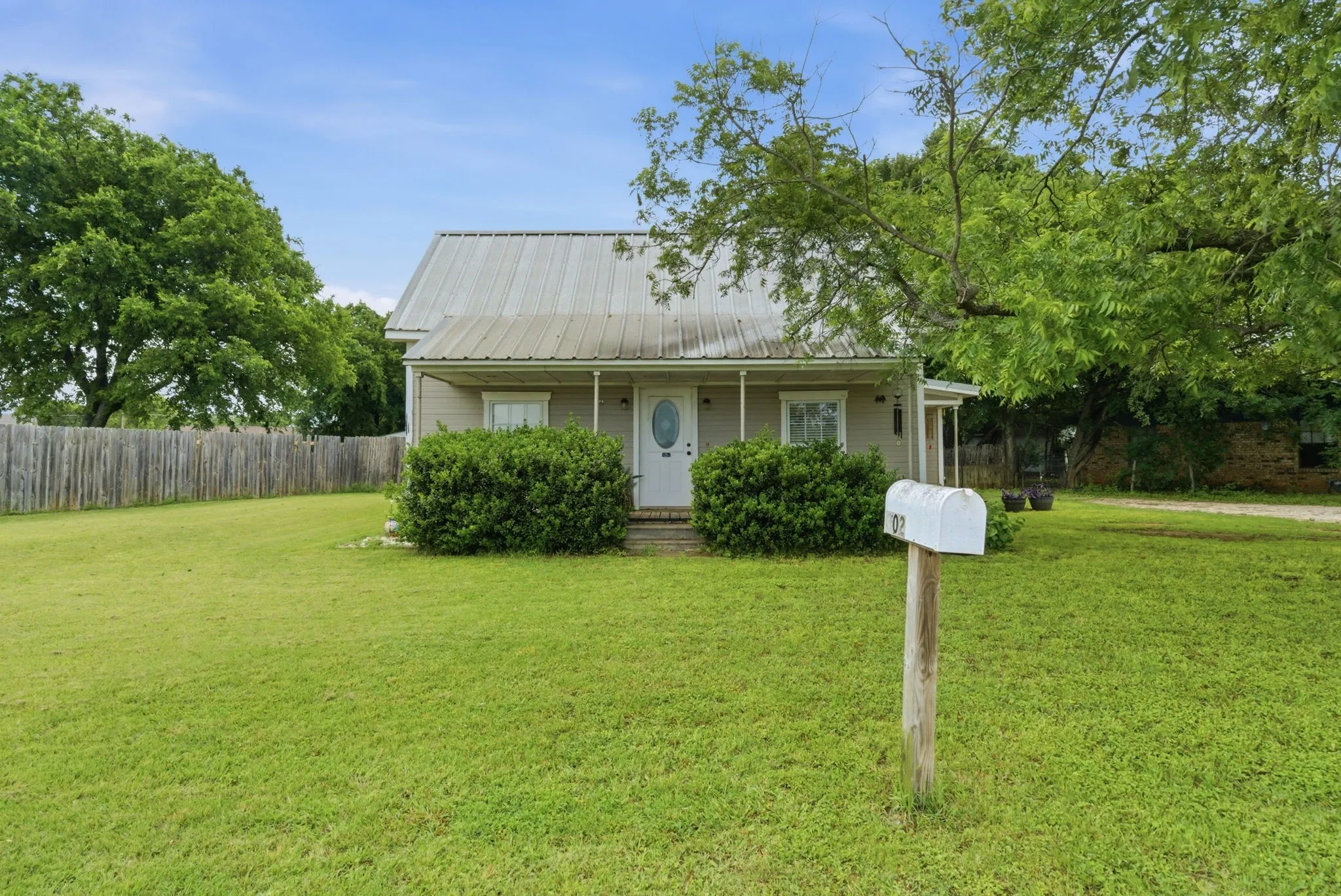 Single-story residence featuring a metal roof, front porch, and white entry door