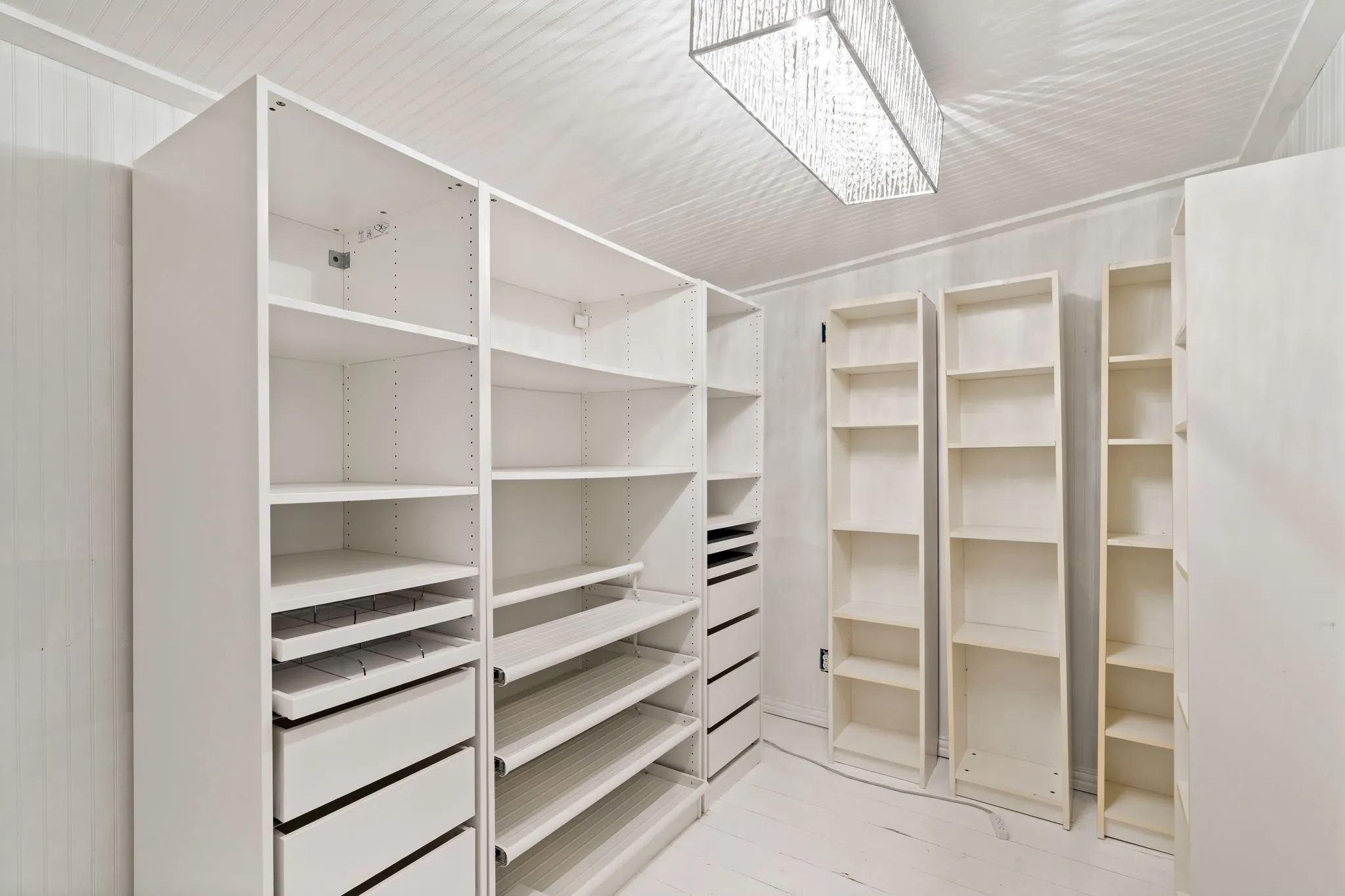 Customizable storage system featuring multiple shelving units, integrated drawers, and pull-out trays