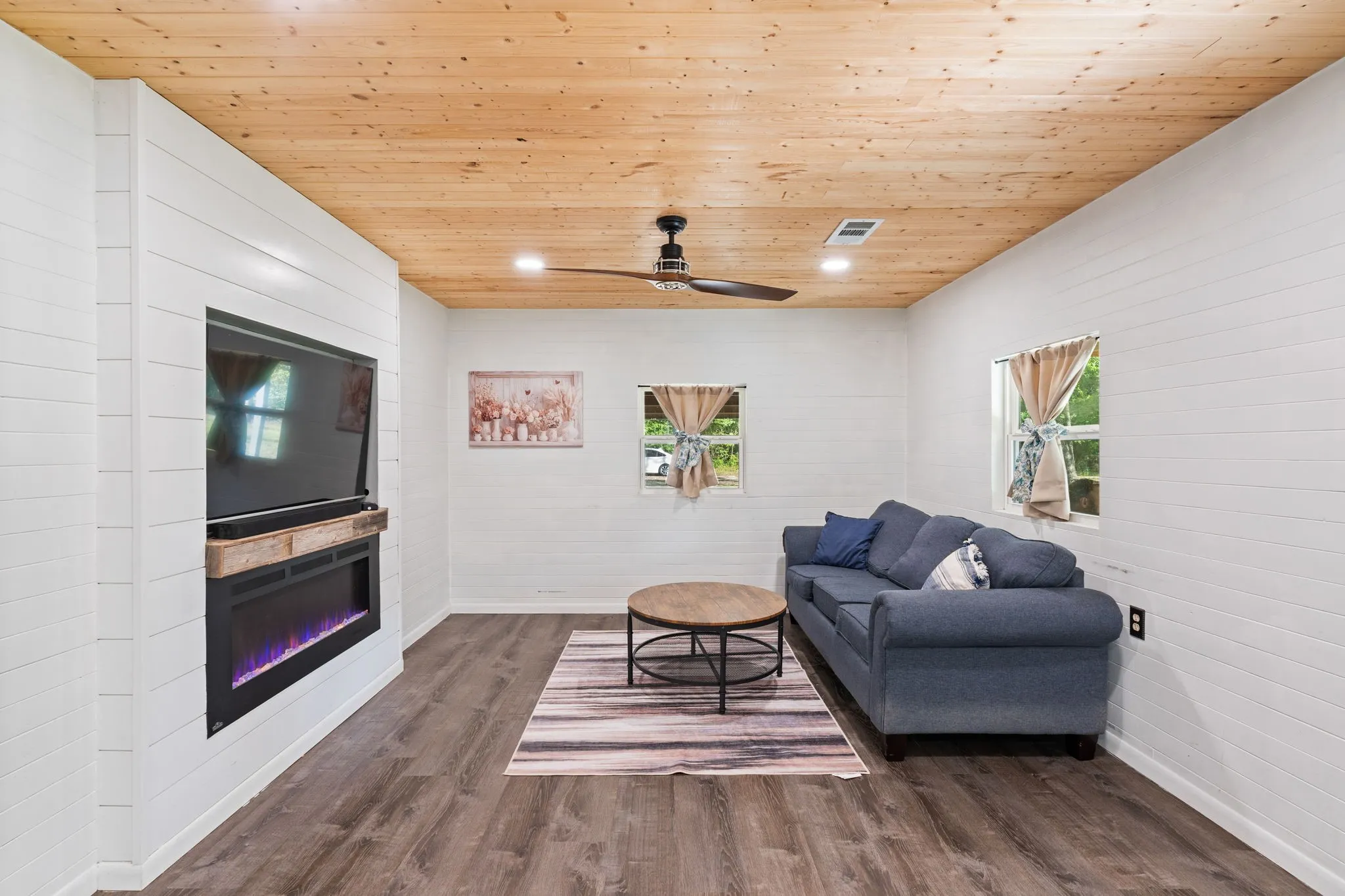 Living area featuring wood-finish flooring and shiplap walls
