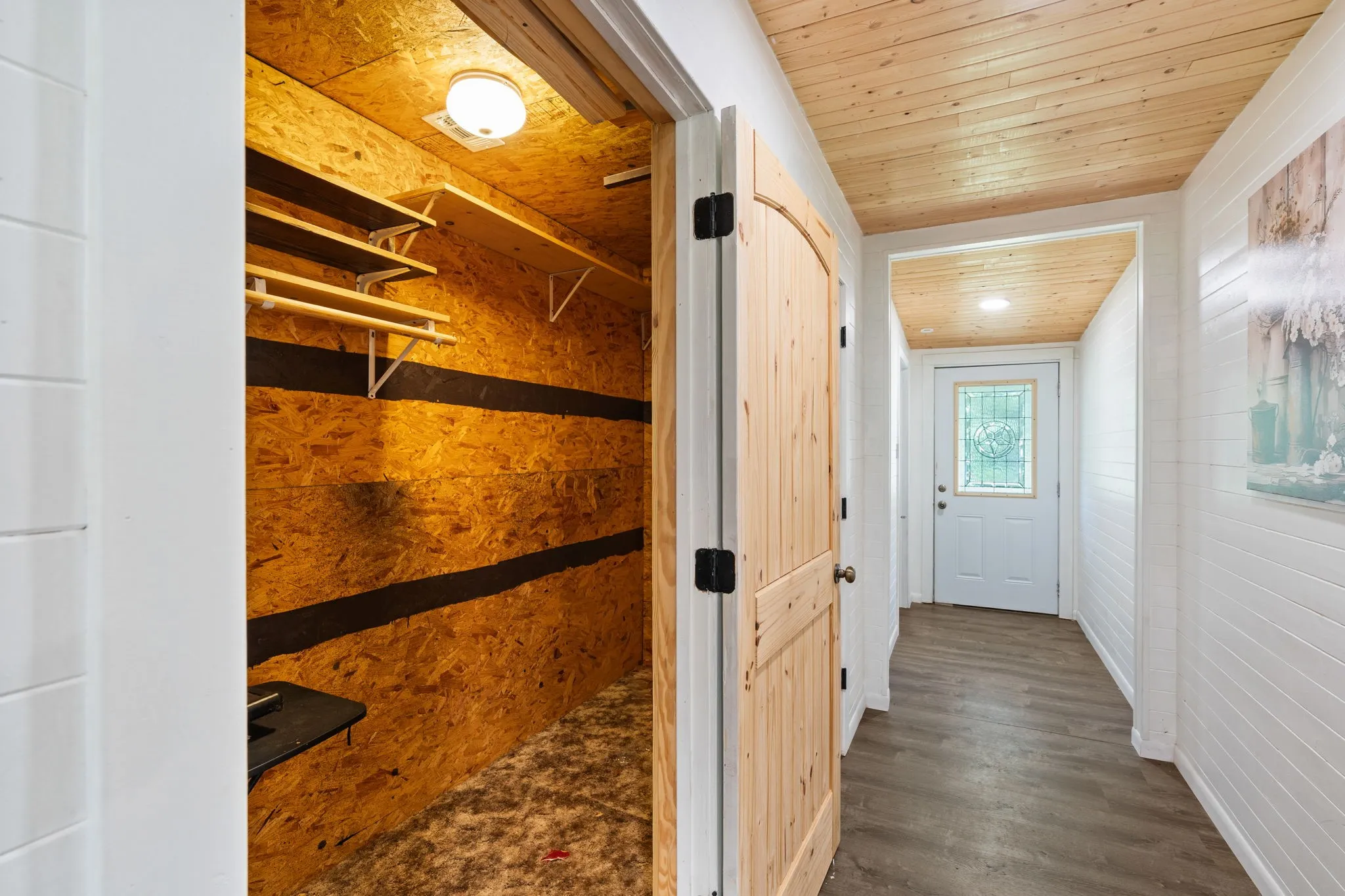 Hallway featuring wood-finish flooring and shiplap walls