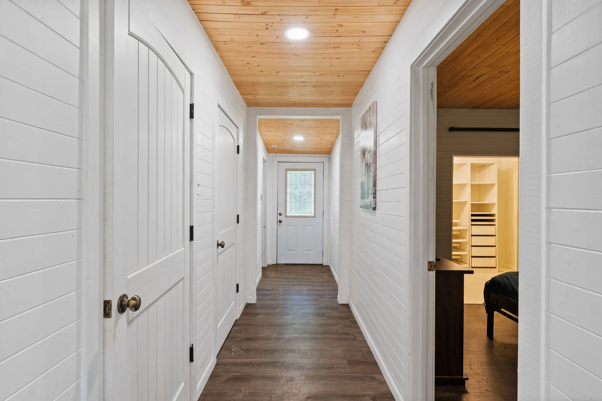 Hallway featuring horizontal plank walls, wood-finish flooring, and a natural wood plank ceiling with recessed lighting