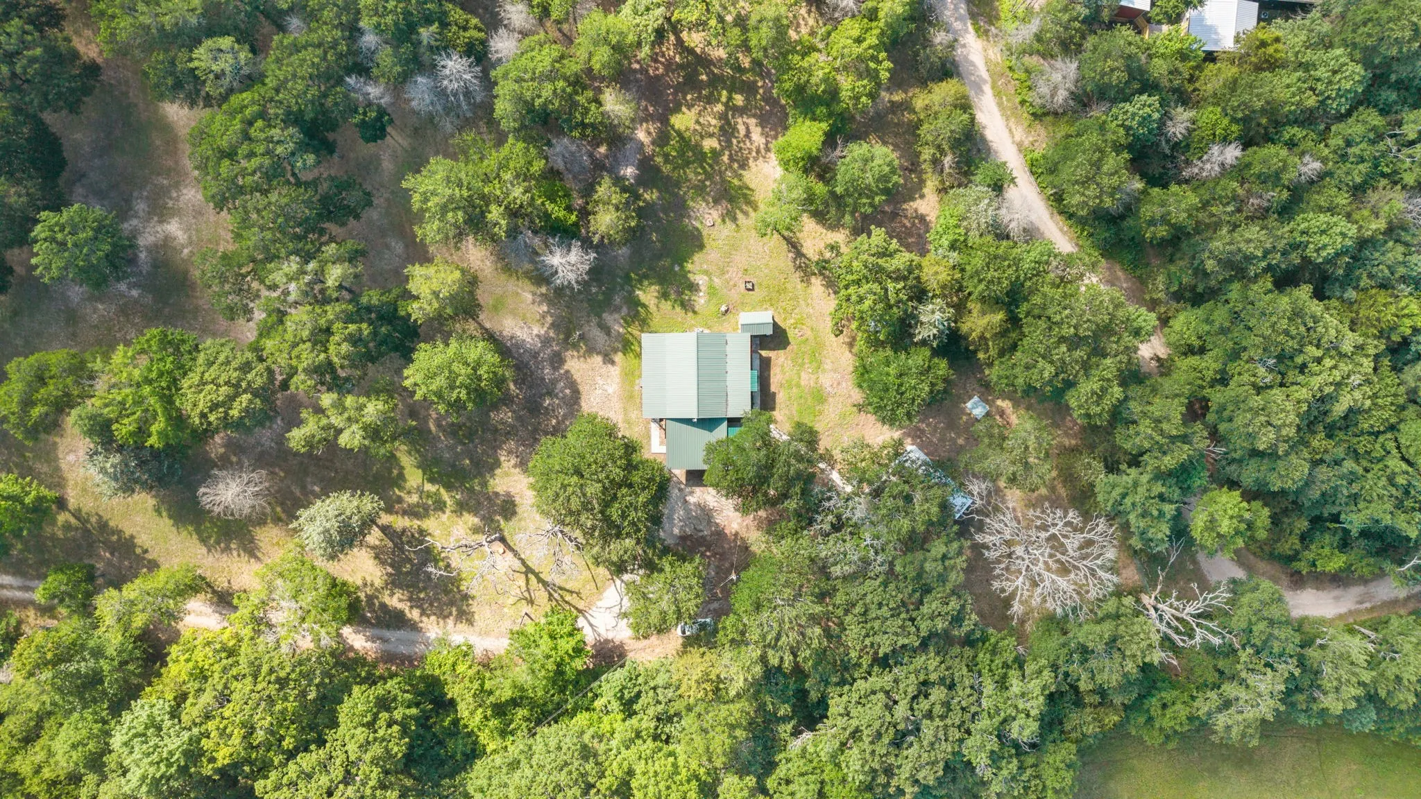 Aerial perspective showcasing a property surrounded by mature trees