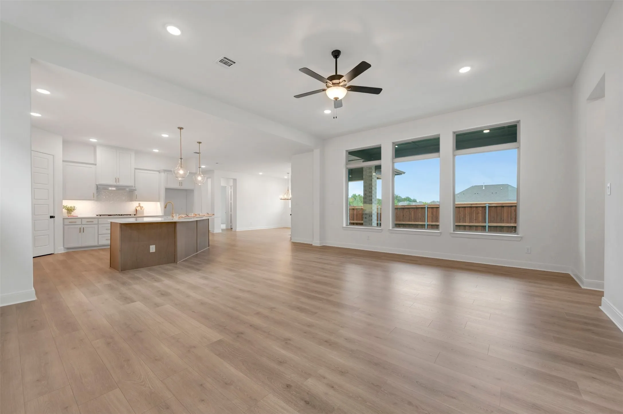 Open-concept living area featuring wood-finish flooring, recessed lighting, and a ceiling fan