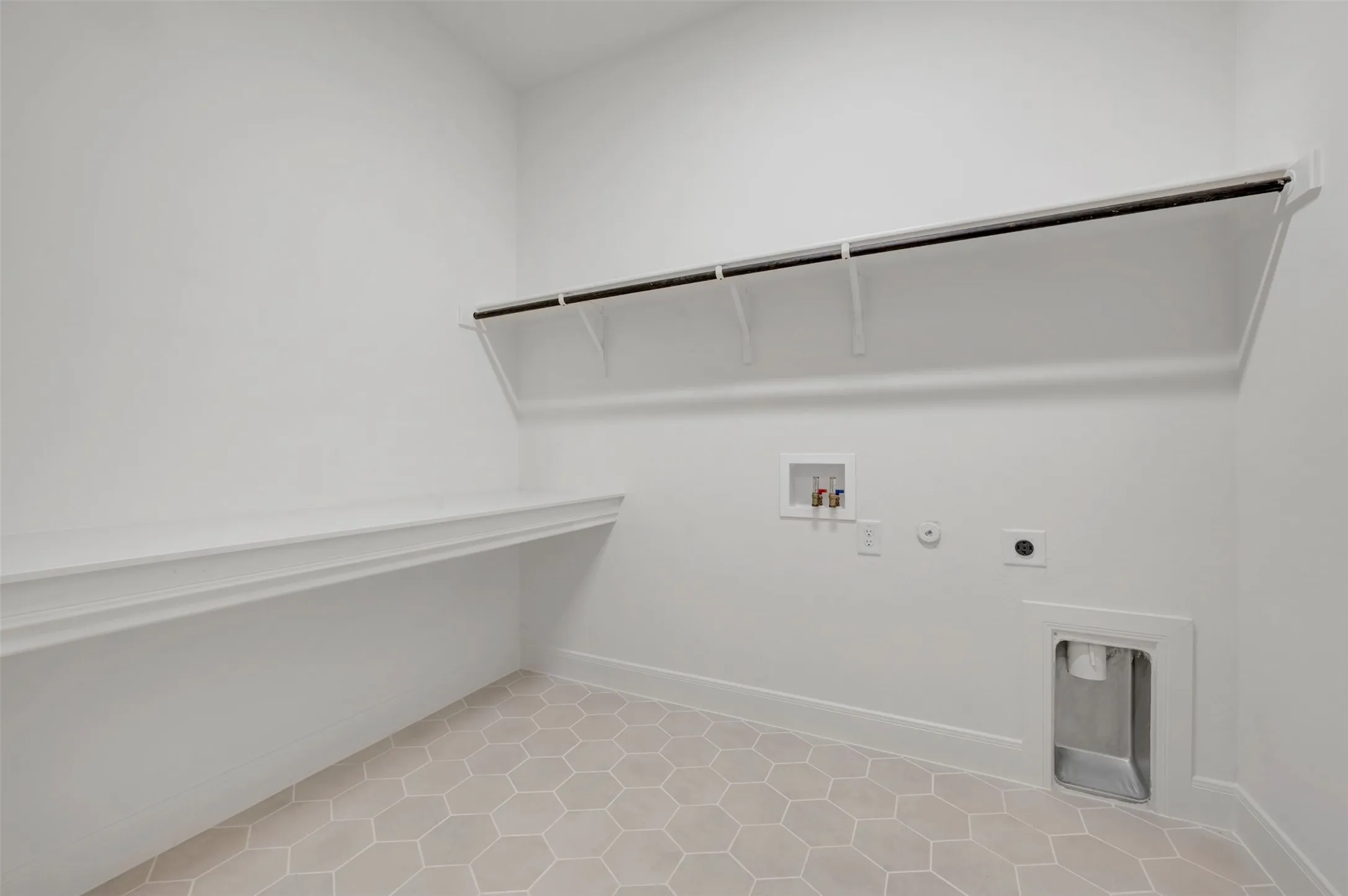 Hexagonal floor tiling, built-in shelving, and a laundry hookup