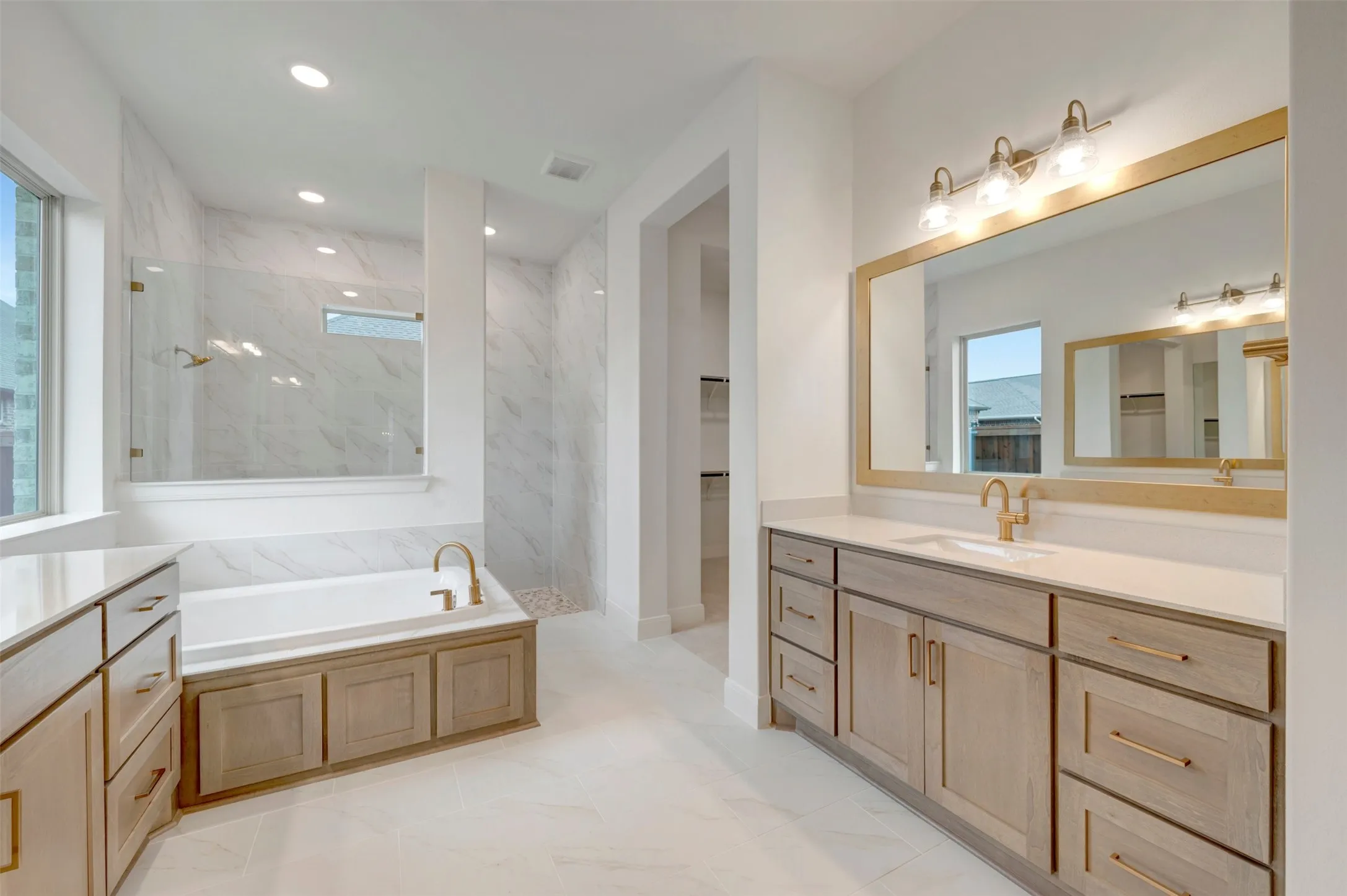 Dual vanities with light wood-finish cabinetry