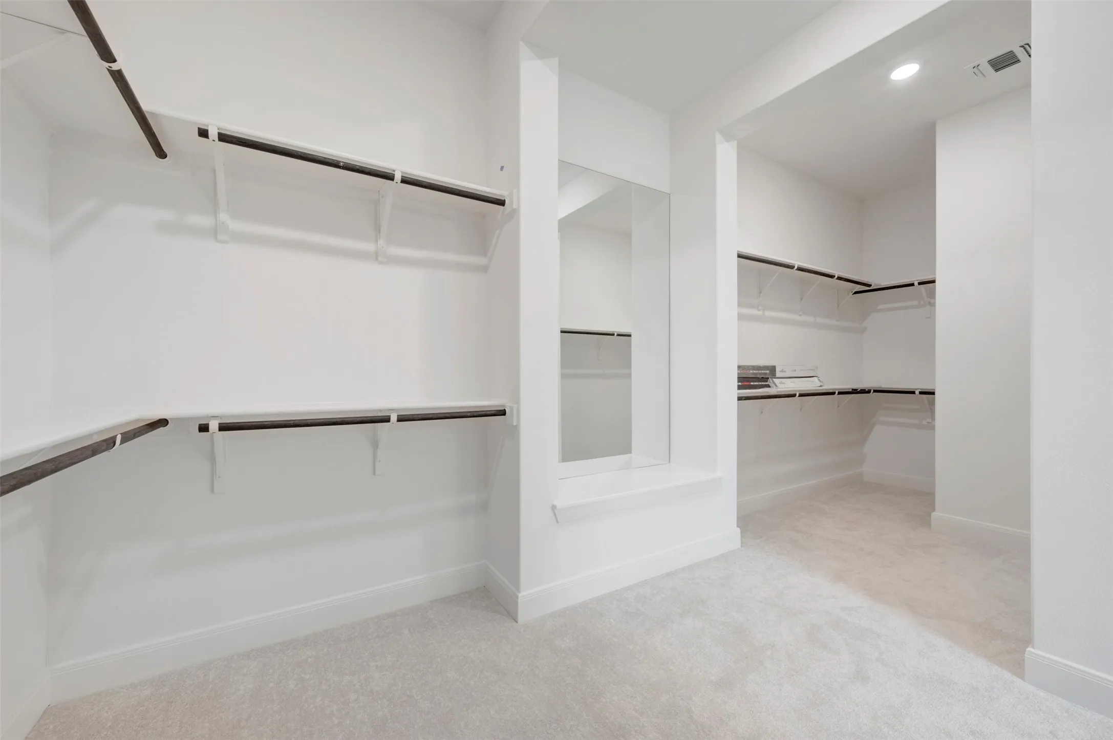Expansive custom closet featuring ample shelving, integrated hanging rods, and a full-length mirror