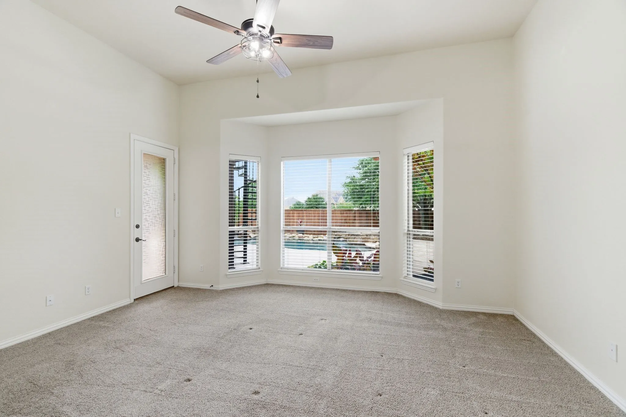 Primary suite with bay windows and door to patio.