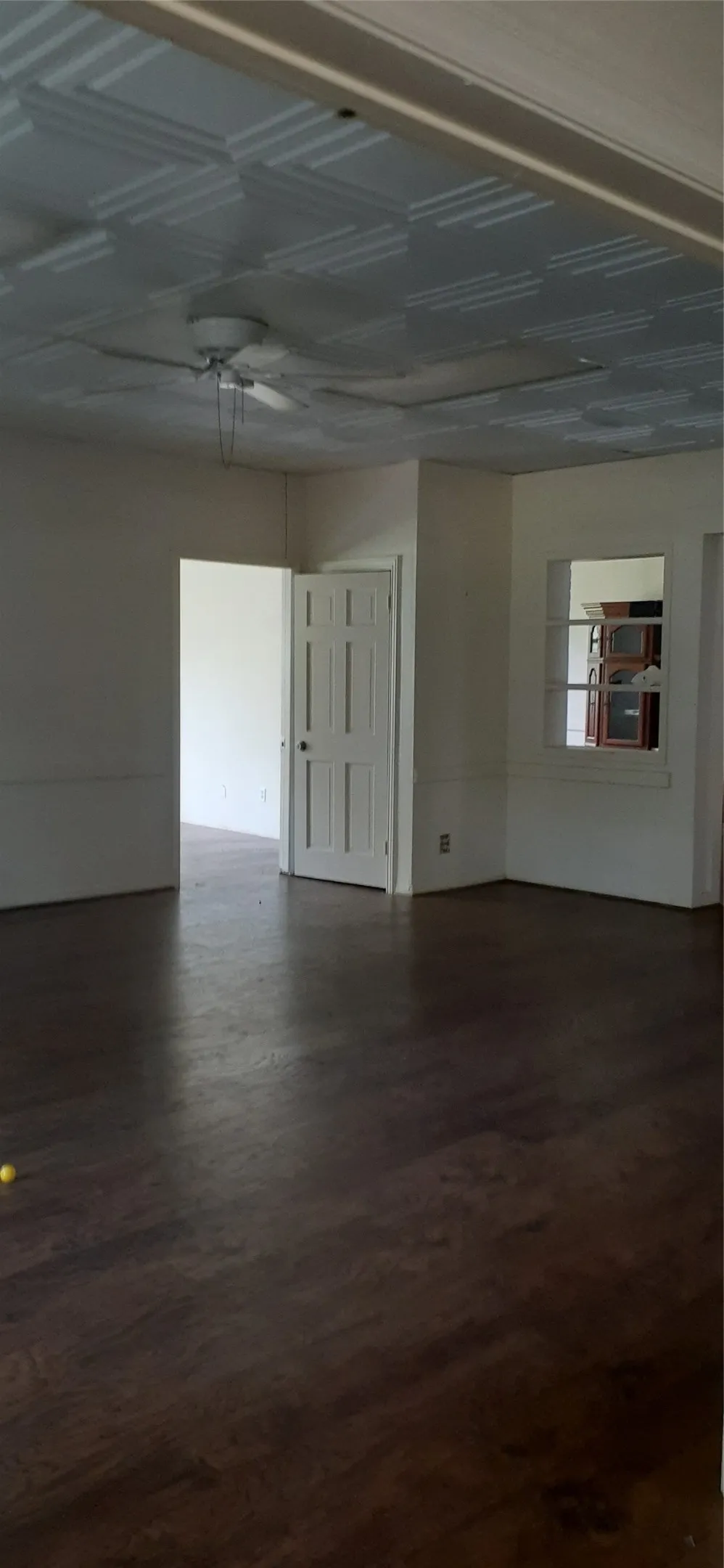 Wood-finish flooring, white paneled door, built-in wall niche, and textured ceiling