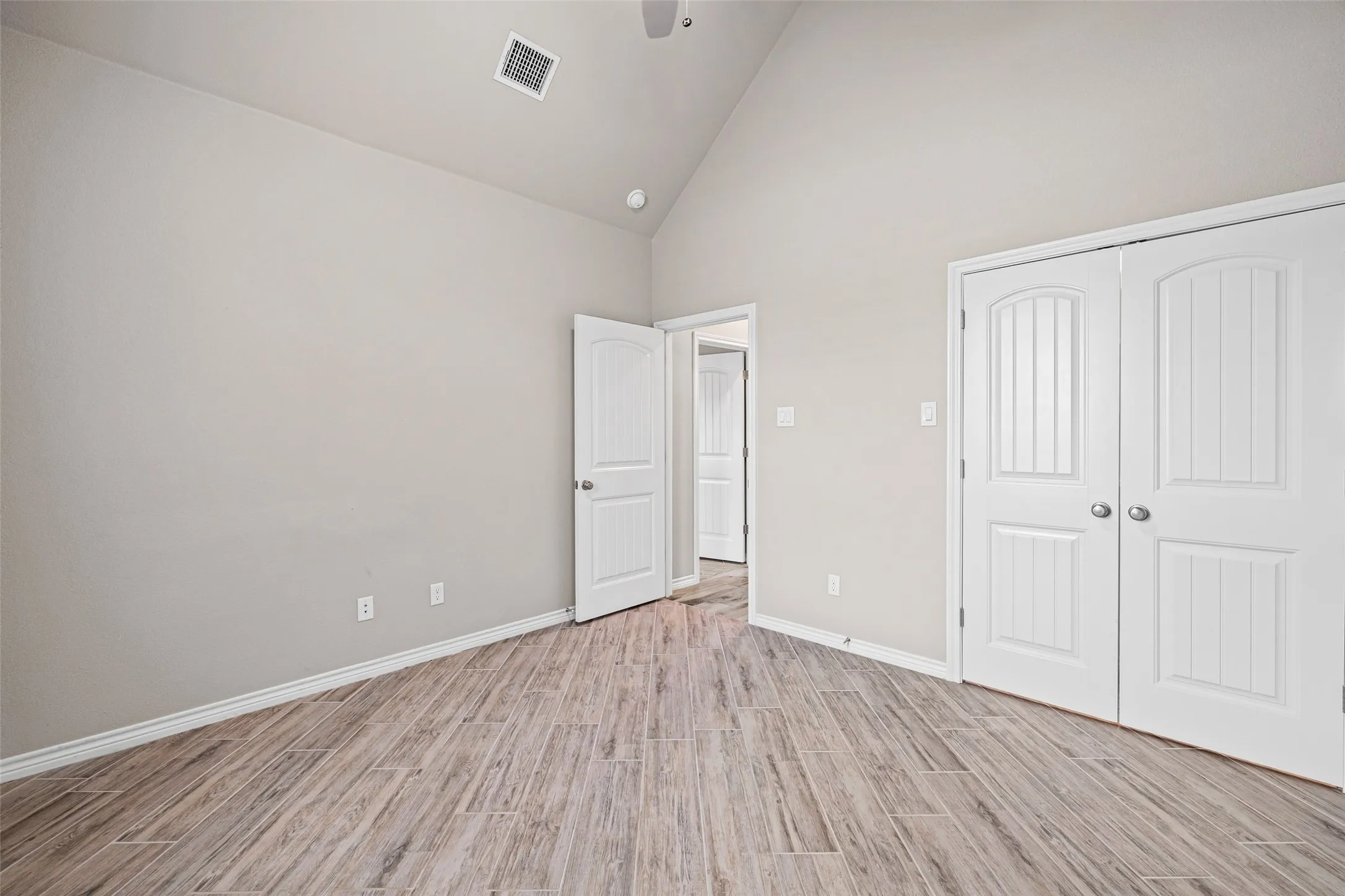 Room featuring wood-finish flooring, vaulted ceiling, and recessed lighting
