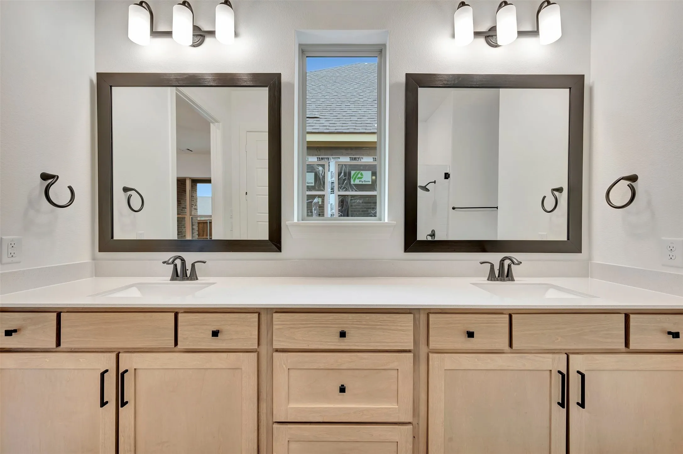 Dual vanity with light wood-finish cabinetry, white countertop, and rectangular undermount sinks
