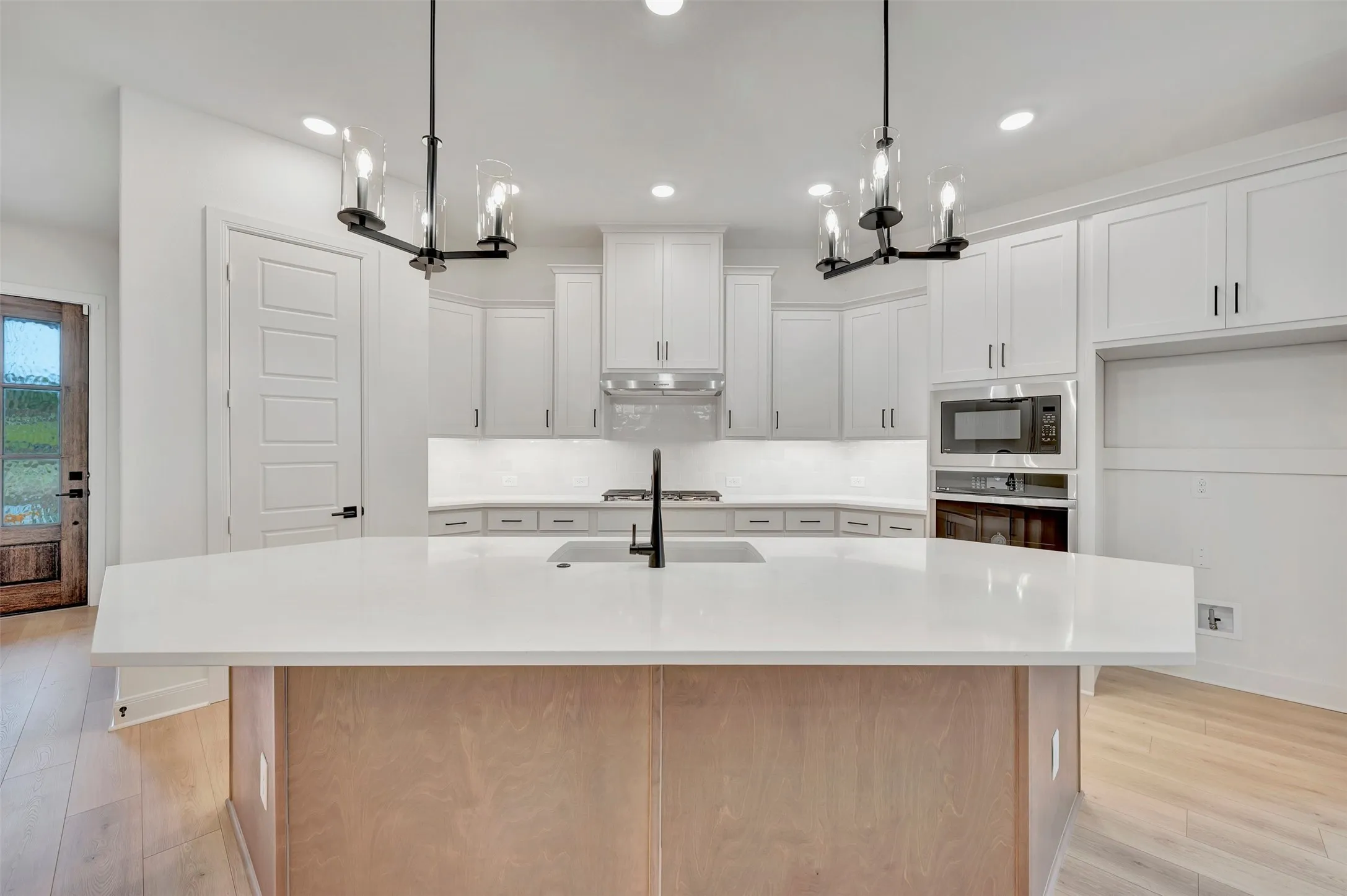 Spacious kitchen island with light-toned wood paneling and a light-toned countertop