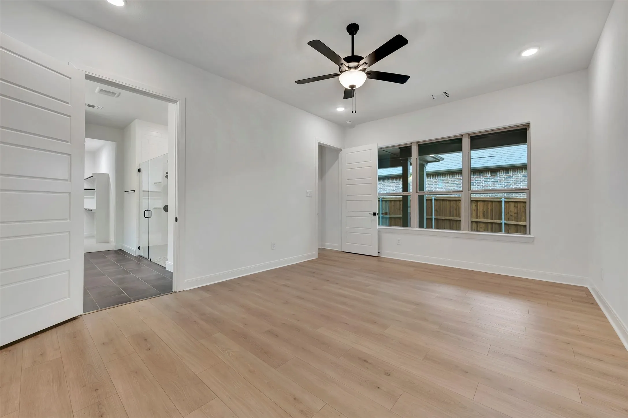 Spacious room featuring wood-finish flooring, recessed lighting, and a contemporary ceiling fan