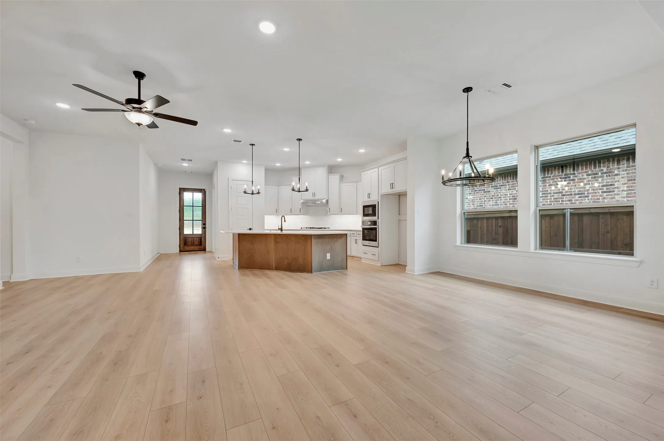 Open-concept living space featuring wood-finish flooring, recessed lighting, and a modern ceiling fan
