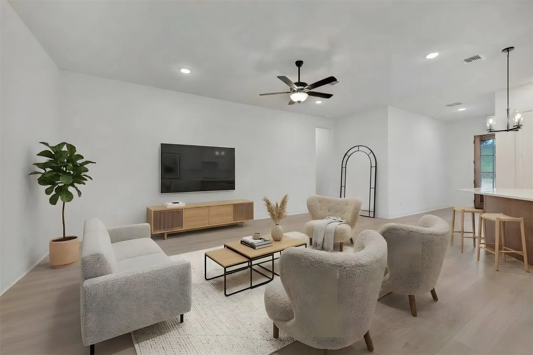 Bright, open-concept living area featuring wood-finish flooring, recessed lighting, and a ceiling fan