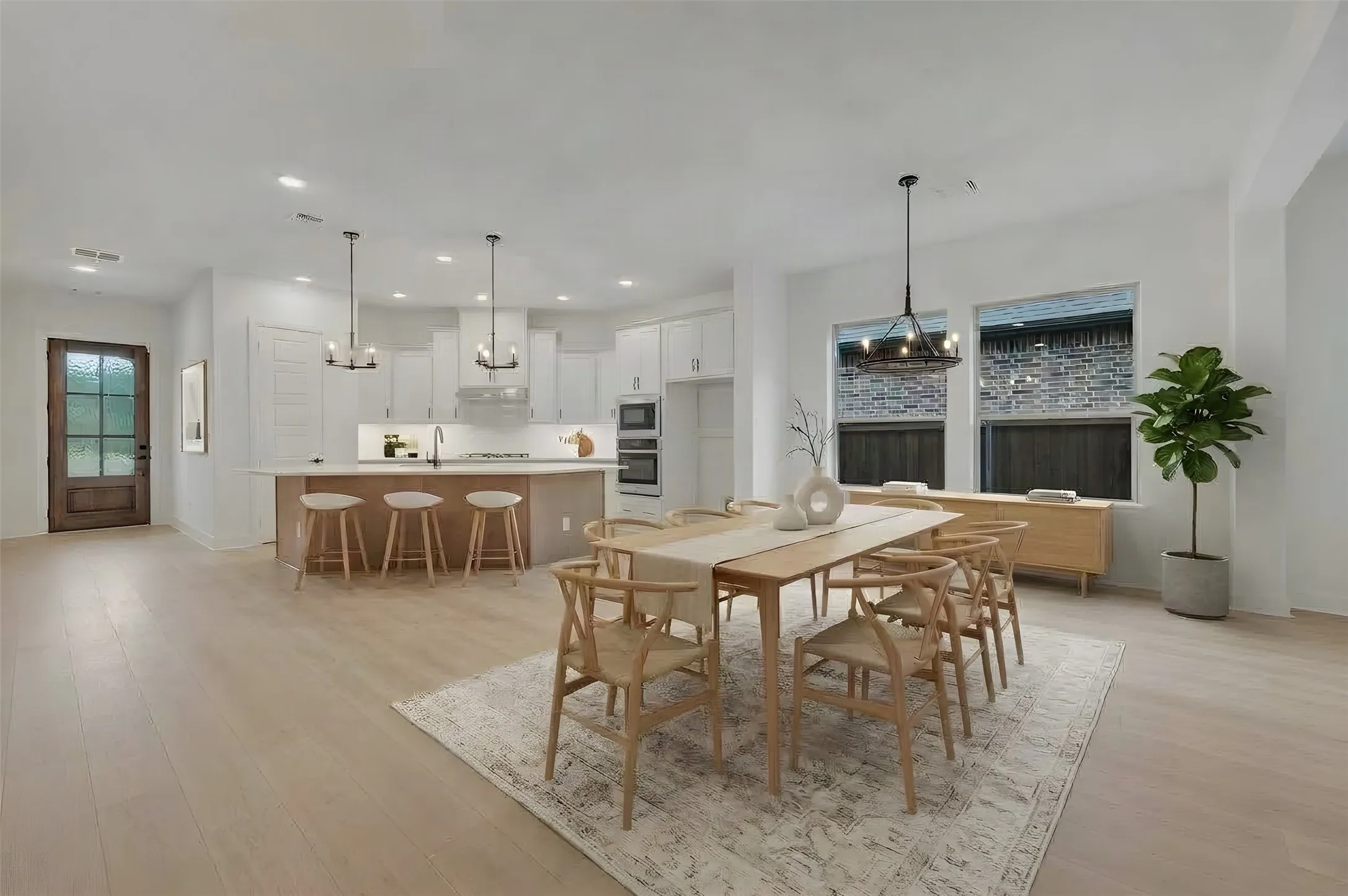 Open-concept living space with light-finish flooring, a kitchen island with seating, pendant lighting, and recessed lighting