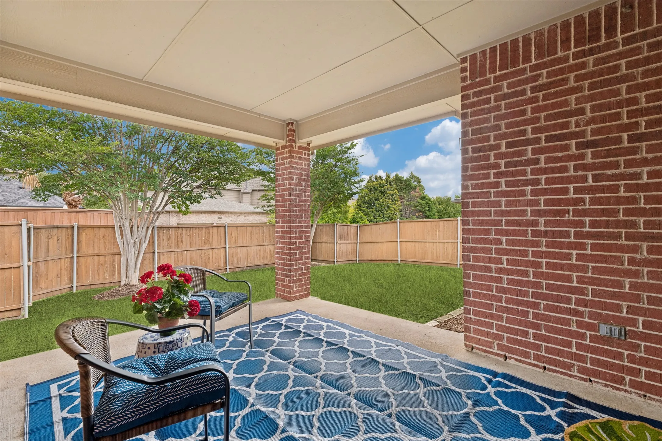 Covered patio featuring a concrete slab and brick pillar