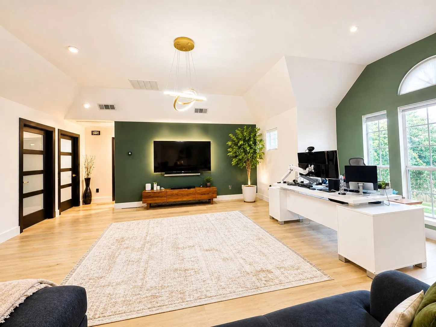 Spacious room featluring wood-finish flooring, vaulted ceilings, and recessed lighting