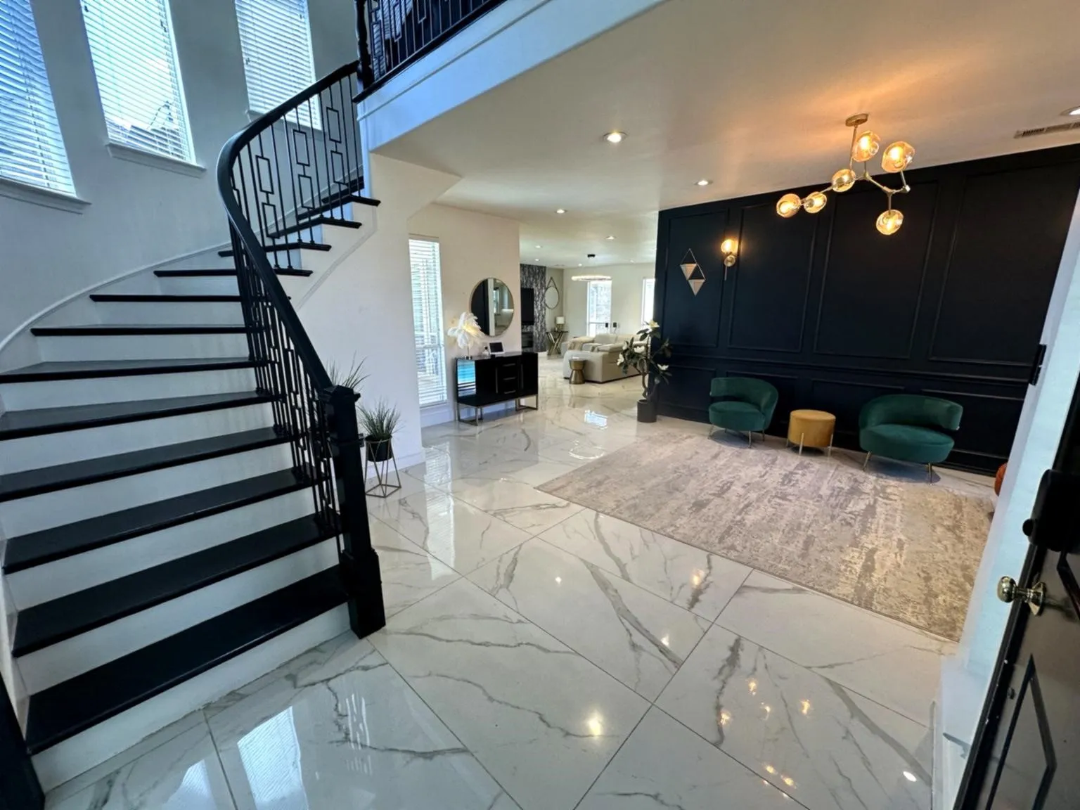 Grand entryway featuring a curved staircase with black newel posts and railings