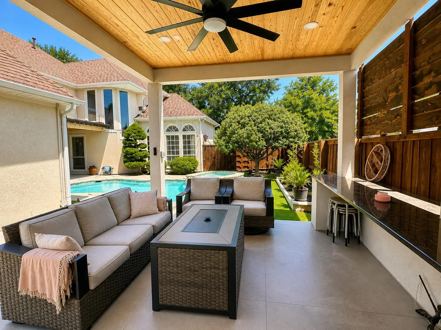 Covered outdoor patio featuring a wood-panel ceiling with recessed lighting and a ceiling fan