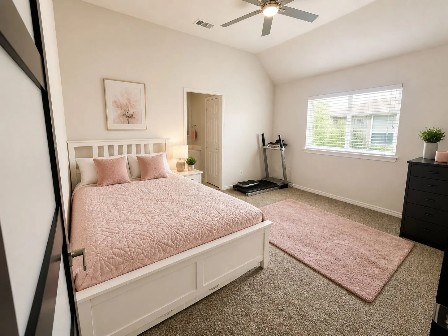 Spacious room featuring vaulted ceilings, neutral wall tones, and carpet flooring