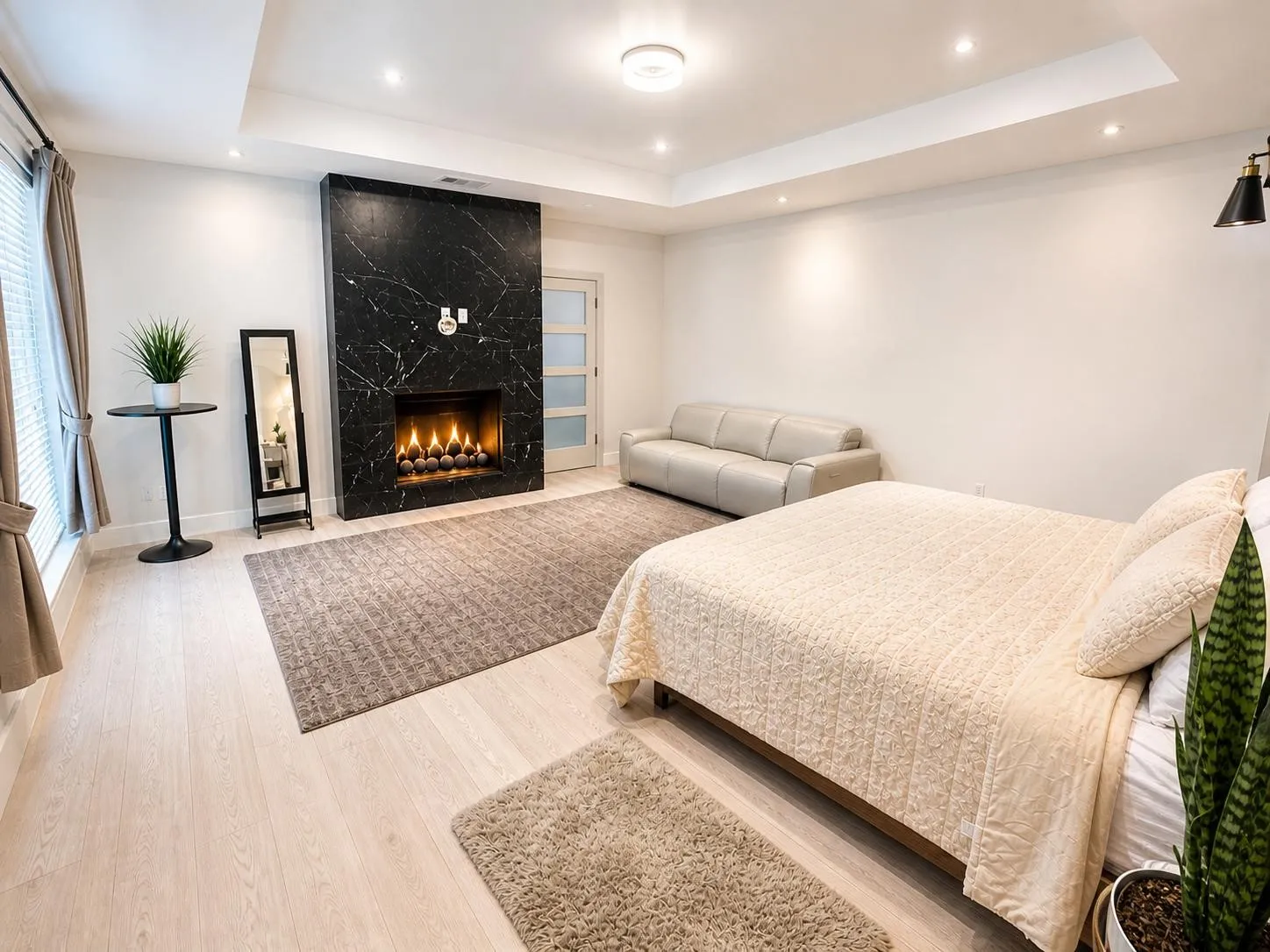 Black-veined fireplace surround with a linear firebox, light wood-finish flooring, and recessed ceiling lighting