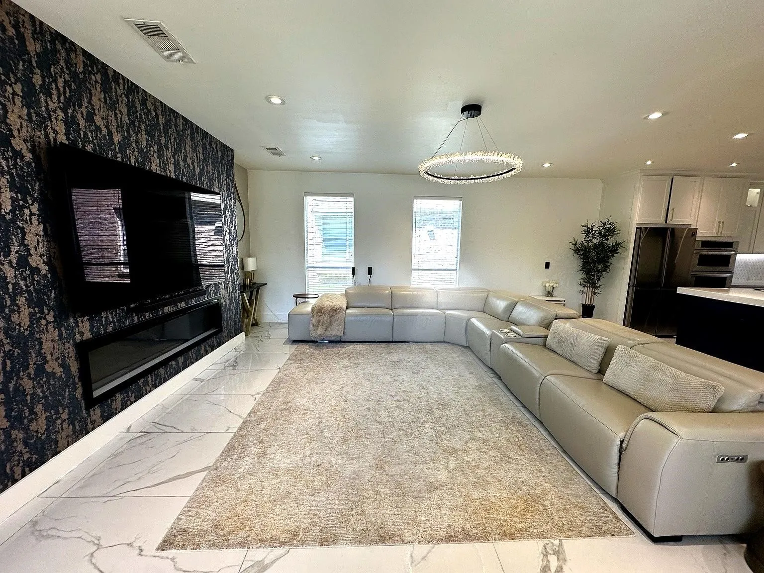 Spacious living area featuring a prominent accent wall with a built-in linear electric fireplace