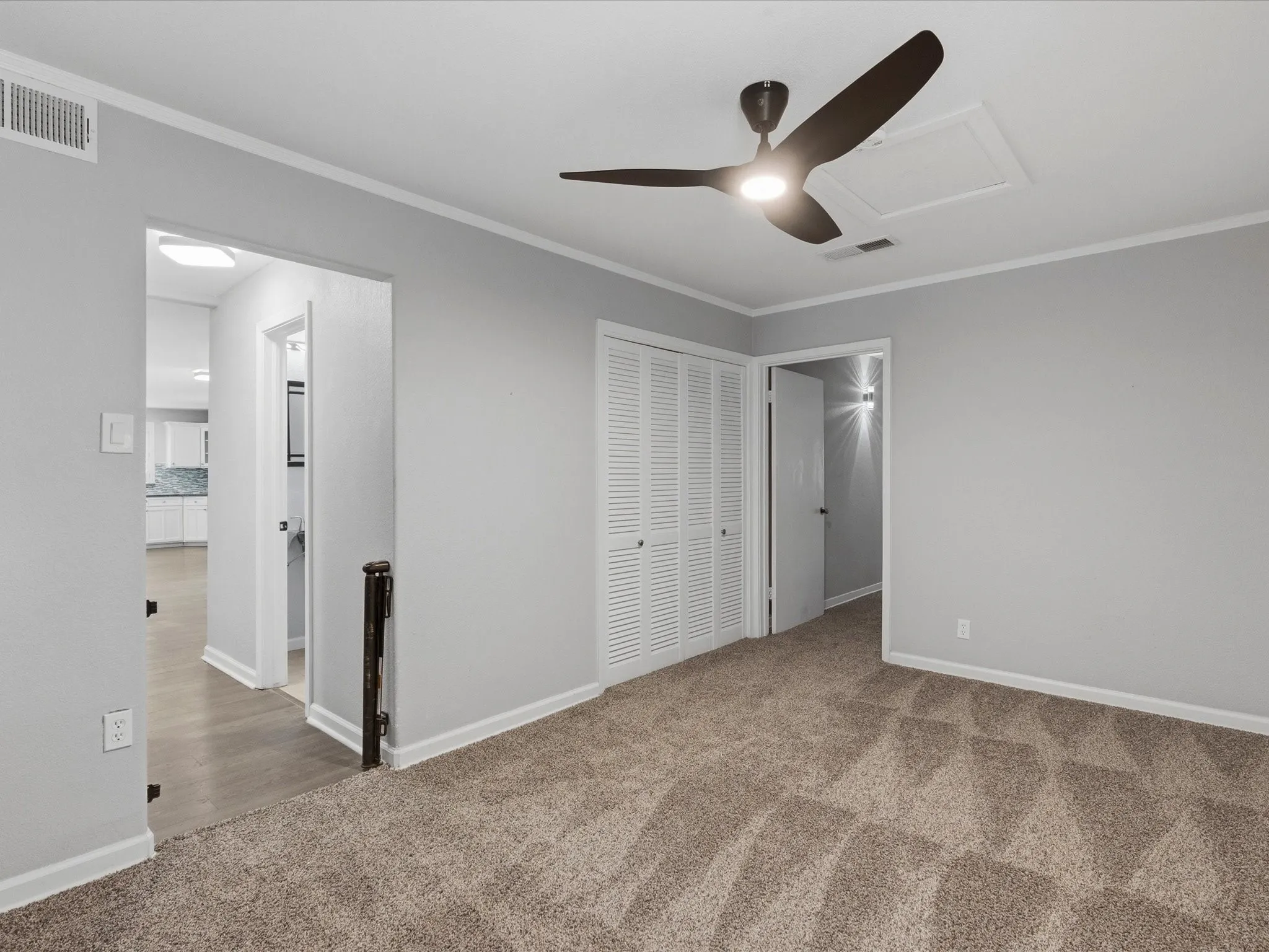Carpeted room featuring a ceiling fan with integrated lighting, bi-fold closet doors, and light gray wall paint