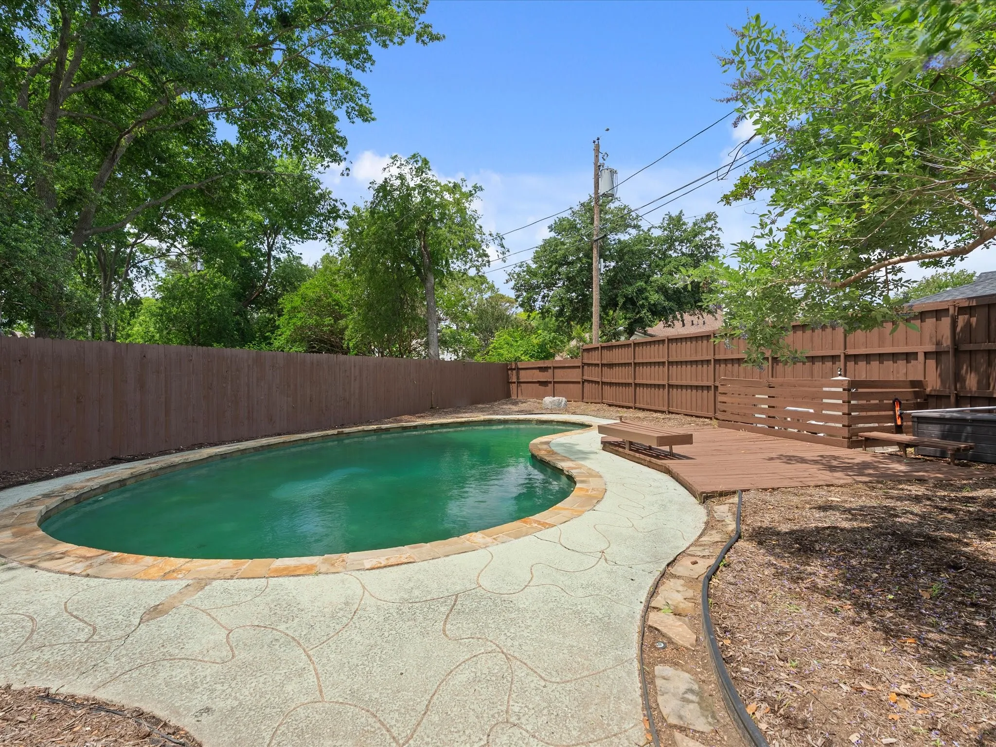 Freeform swimming pool with flagstone coping and a textured concrete deck