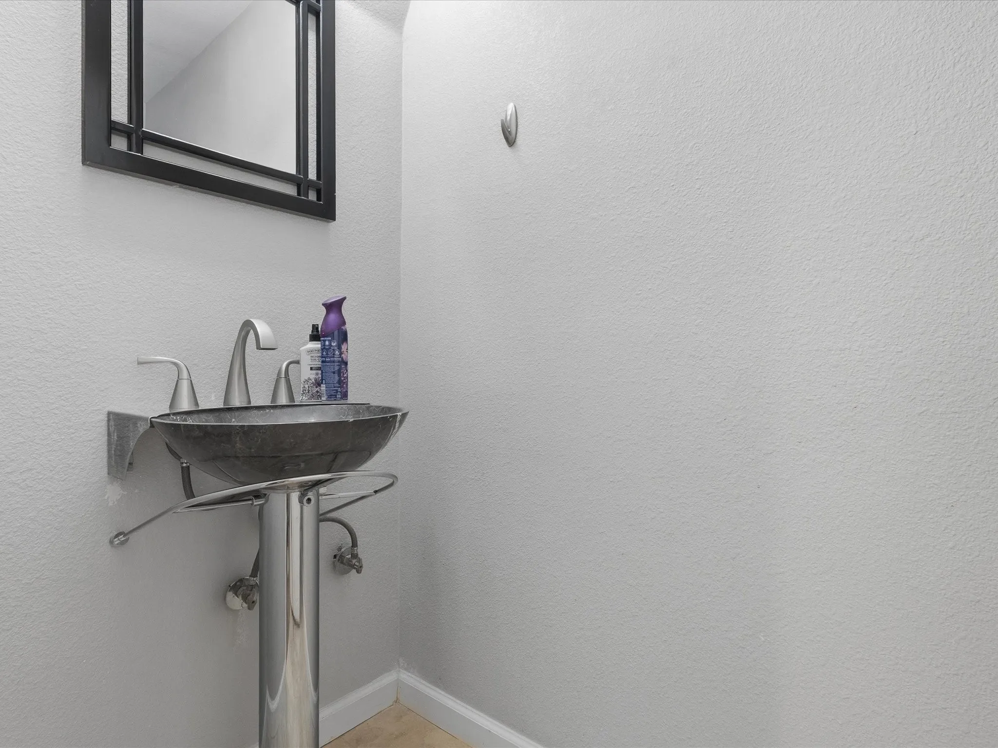Pedestal sink with a vessel bowl and brushed nickel fixtures