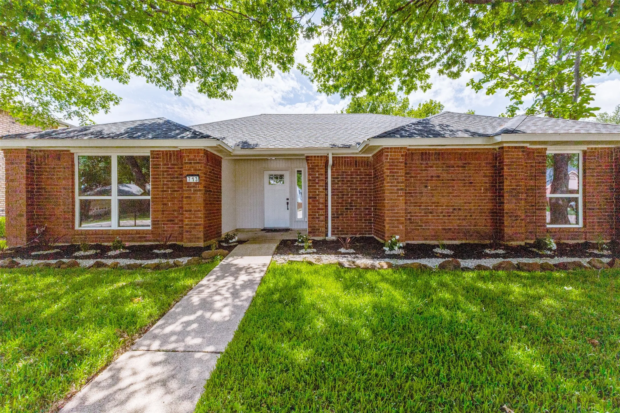 Brick facade with white trim and a contrasting dark roof