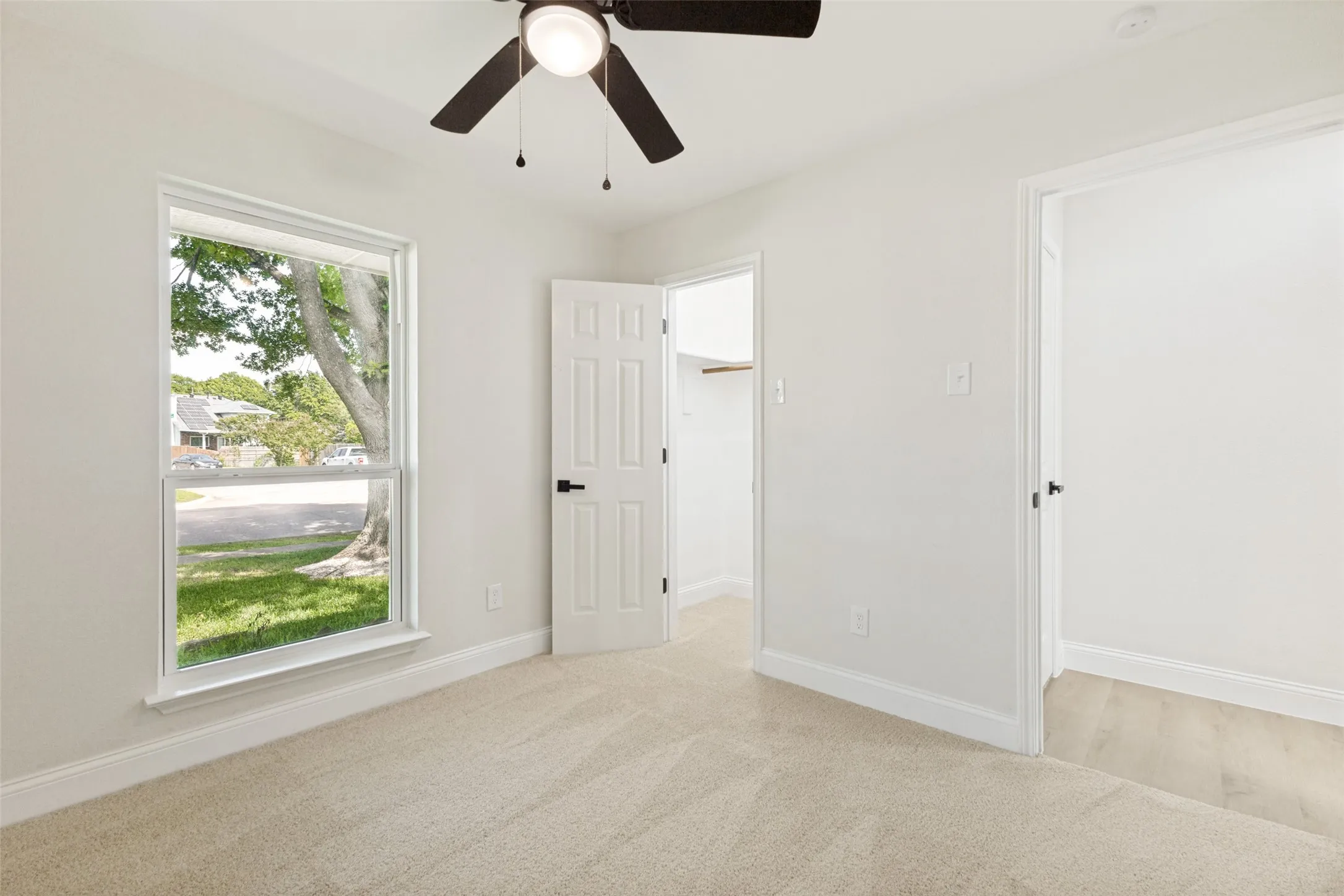 Bedroom featuring neutral-toned carpet flooring and a double-hung window