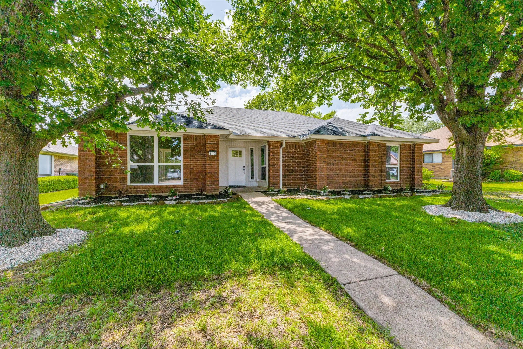 Traditional brick exterior with a white front door and surrounding sidelights