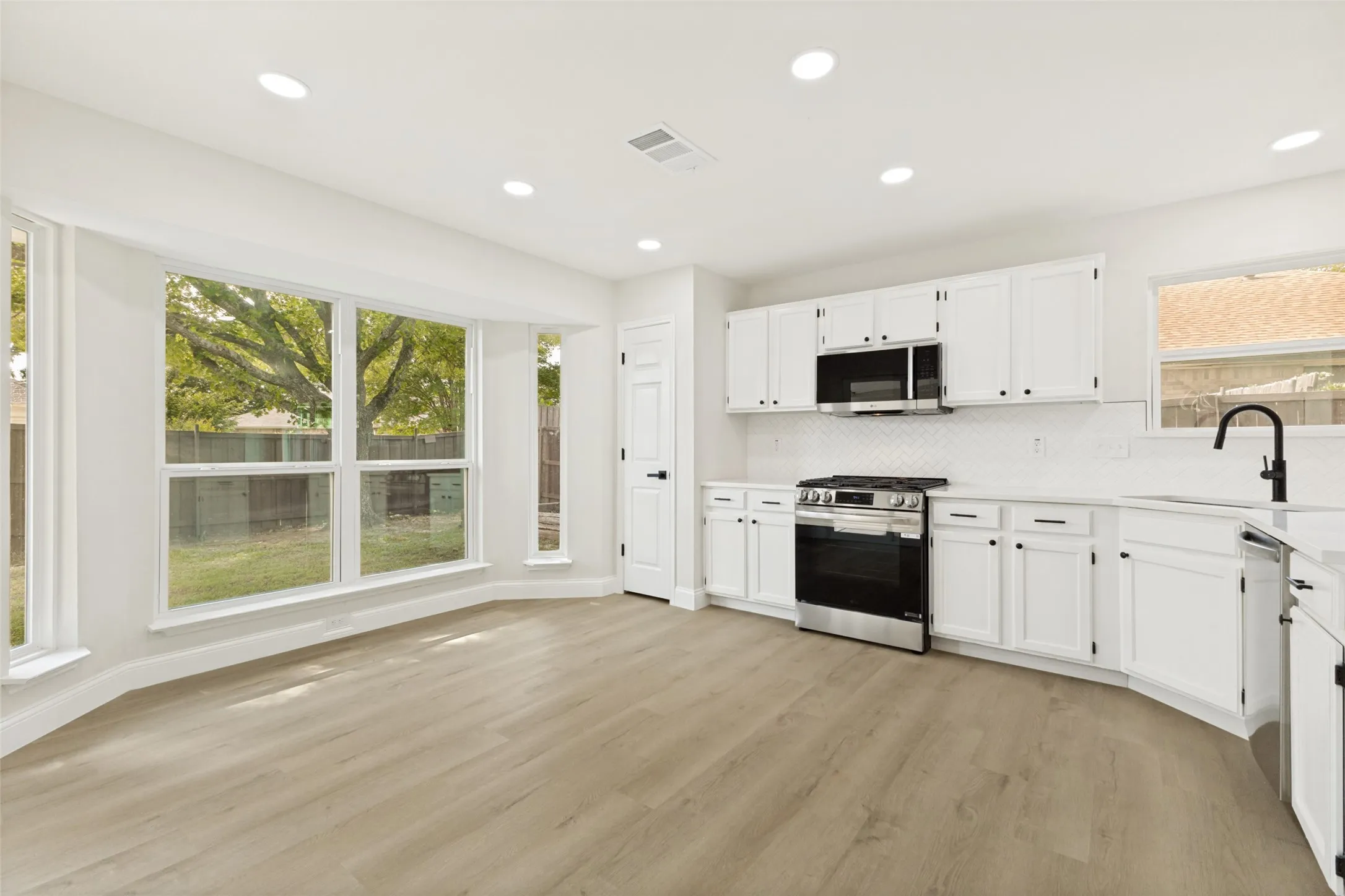 Kitchen and dining area featuring light wood-finish flooring
