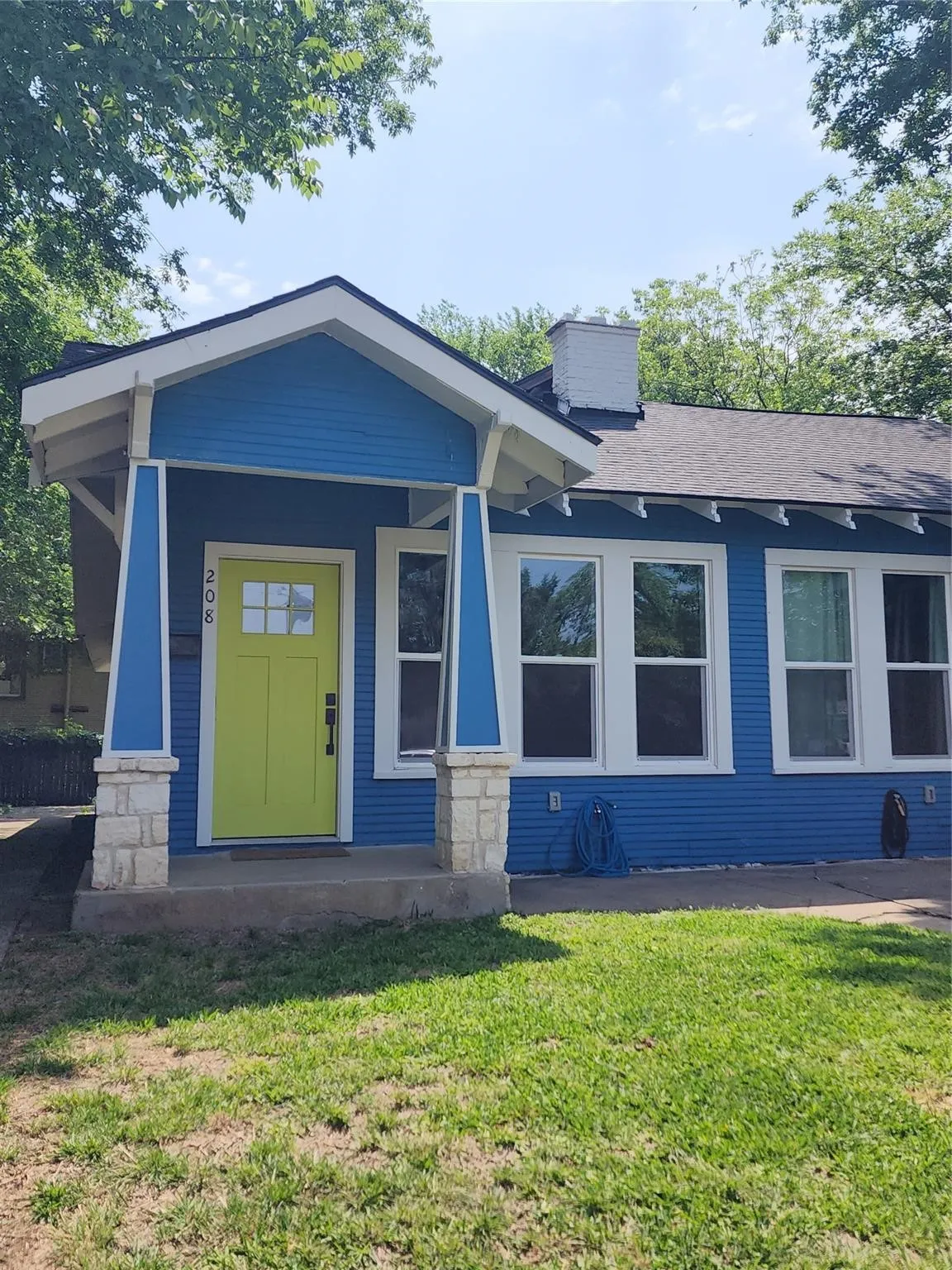 Blue exterior siding with white trim and a vibrant yellow front door