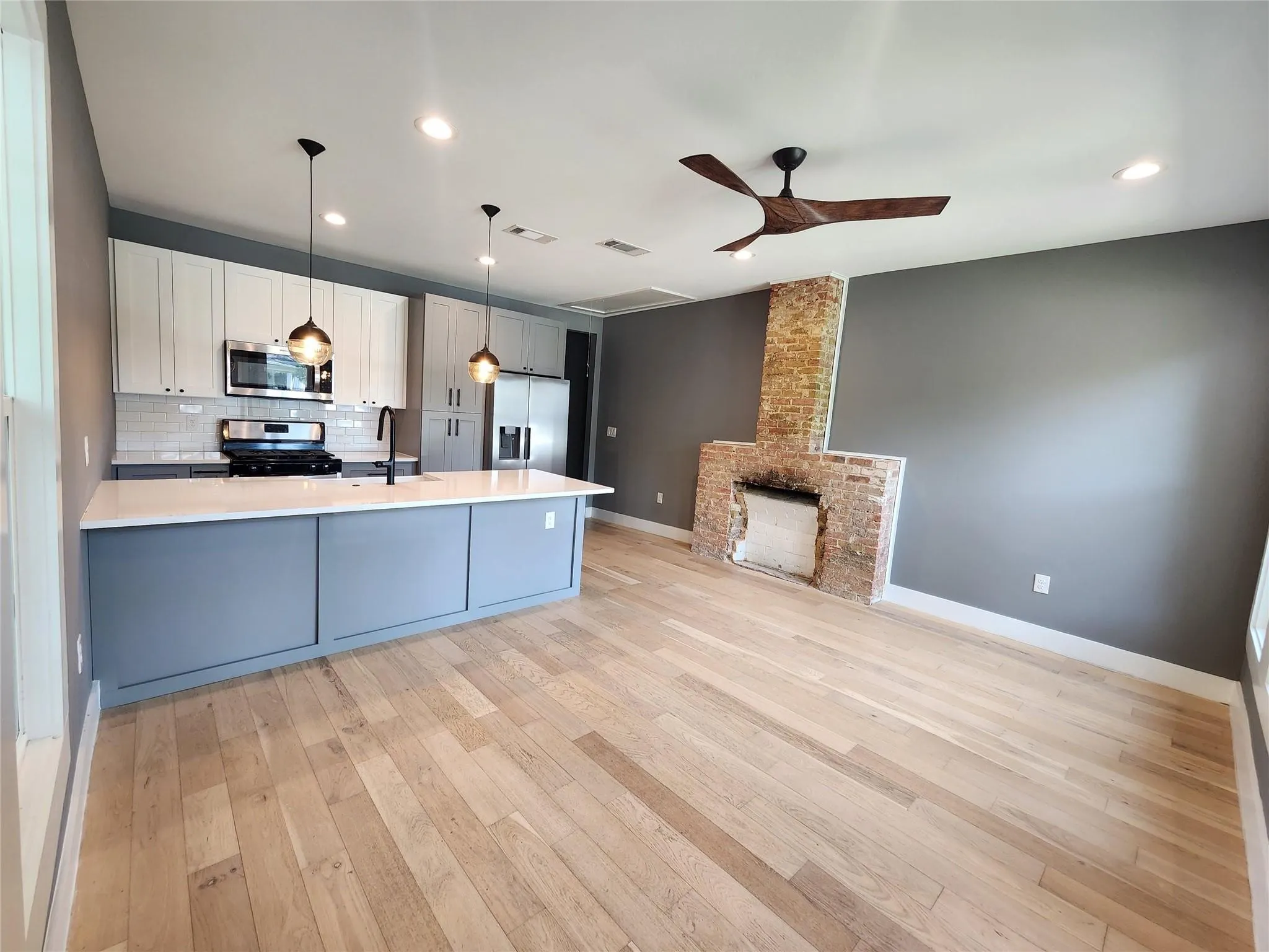 Open-concept living space with light wood-finish flooring