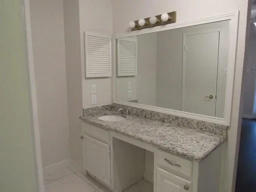 Bathroom featuring tile patterned flooring and vanity