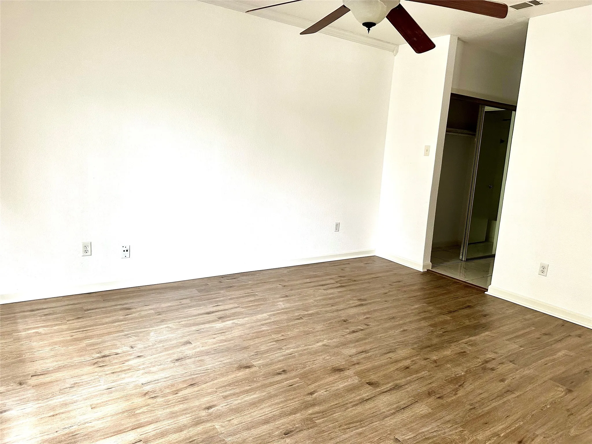 Upper bedroom featuring light hardwood / wood-style flooring and ceiling fan