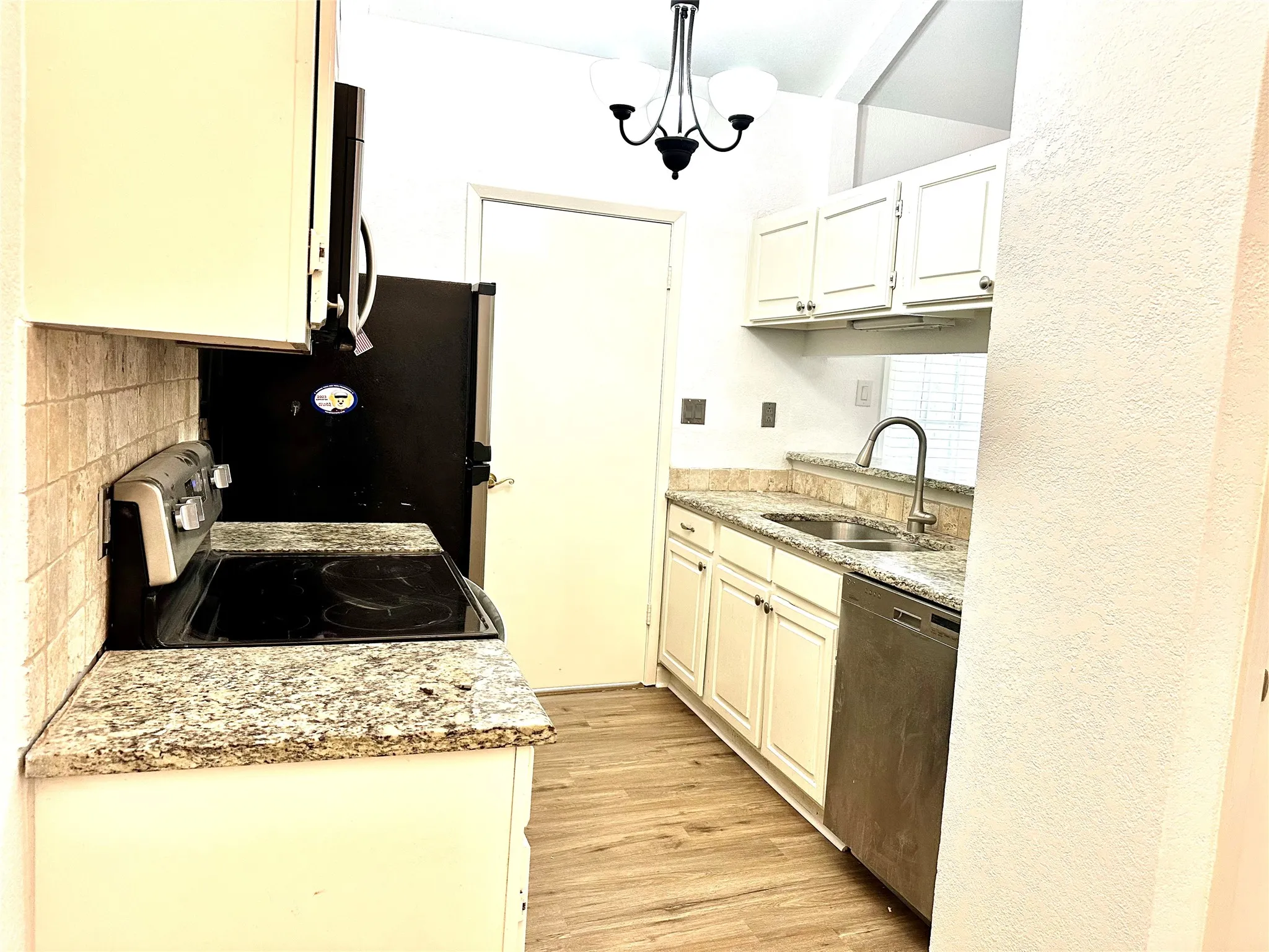 Kitchen featuring decorative backsplash, light hardwood / wood-style flooring, dishwashing machine, range, and sink