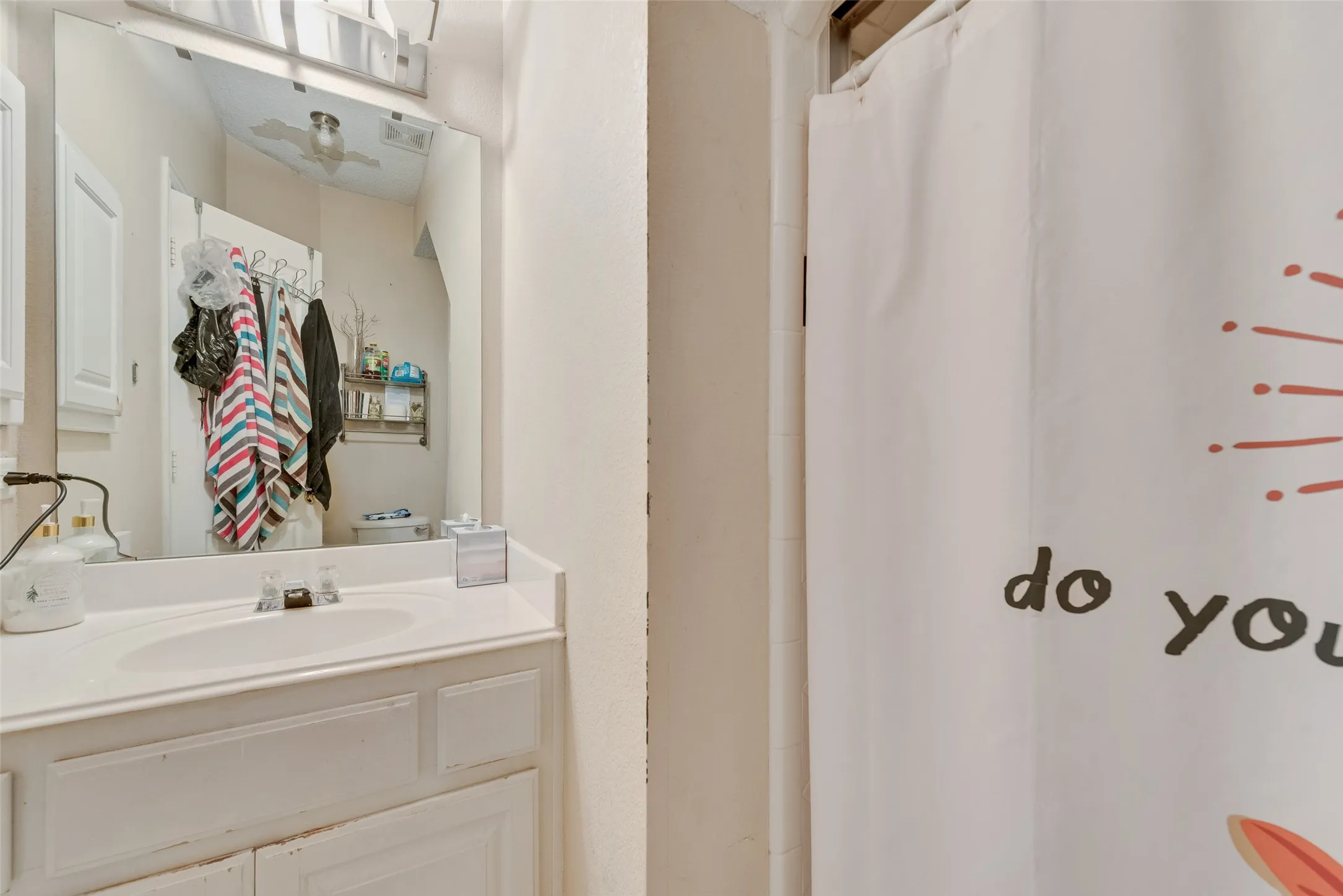 White vanity with integrated sink and chrome faucet, featuring a large wall-mounted mirror