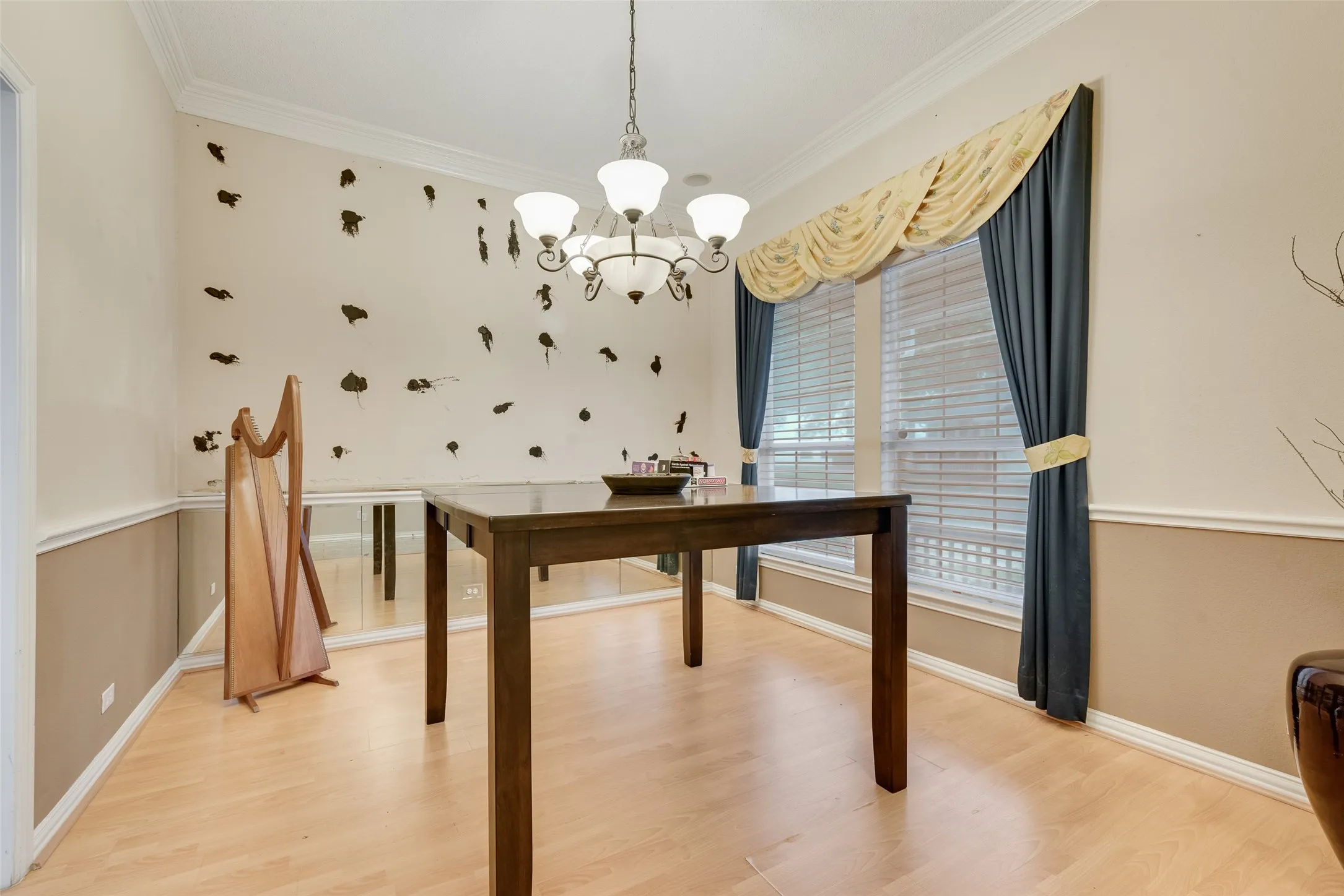 Spacious interior featuring wood-finish flooring, a multi-light chandelier, and crown molding