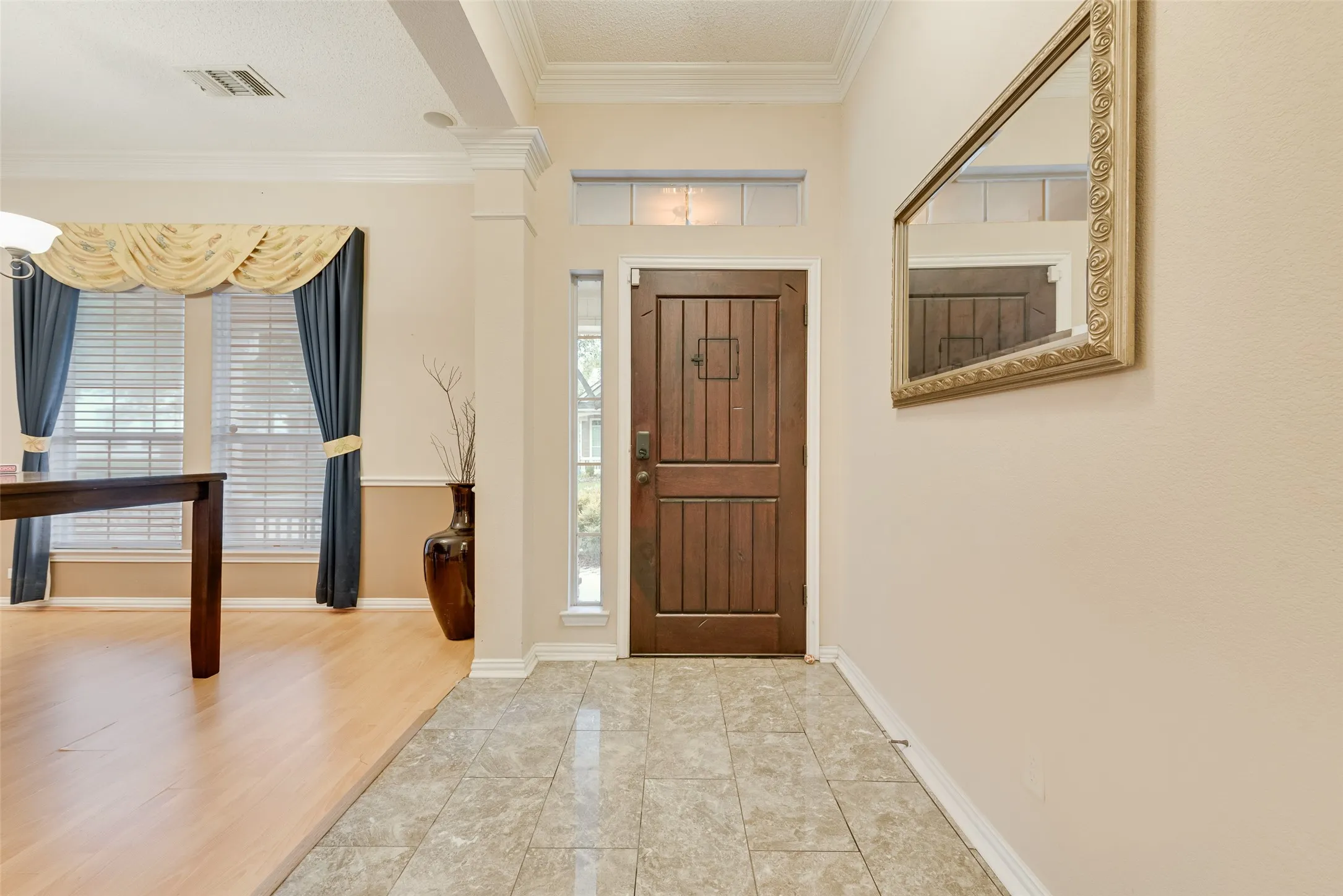 Entryway featuring wood-panel door, transom window, and tiled flooring