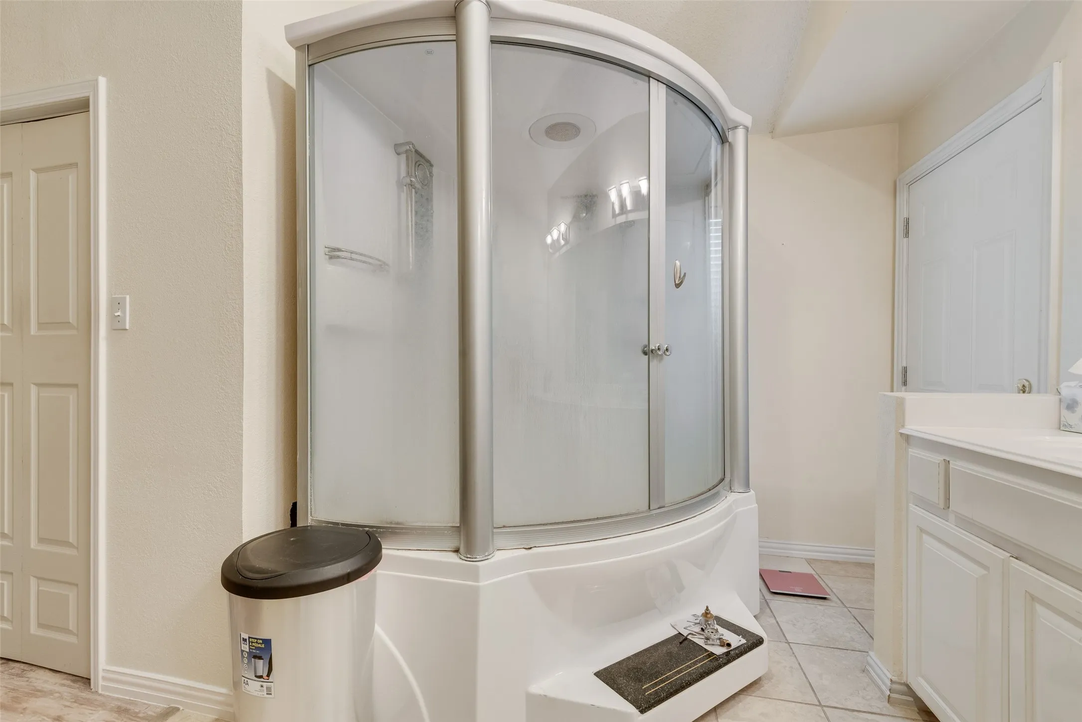 Enclosed shower with curved glass doors and integrated base