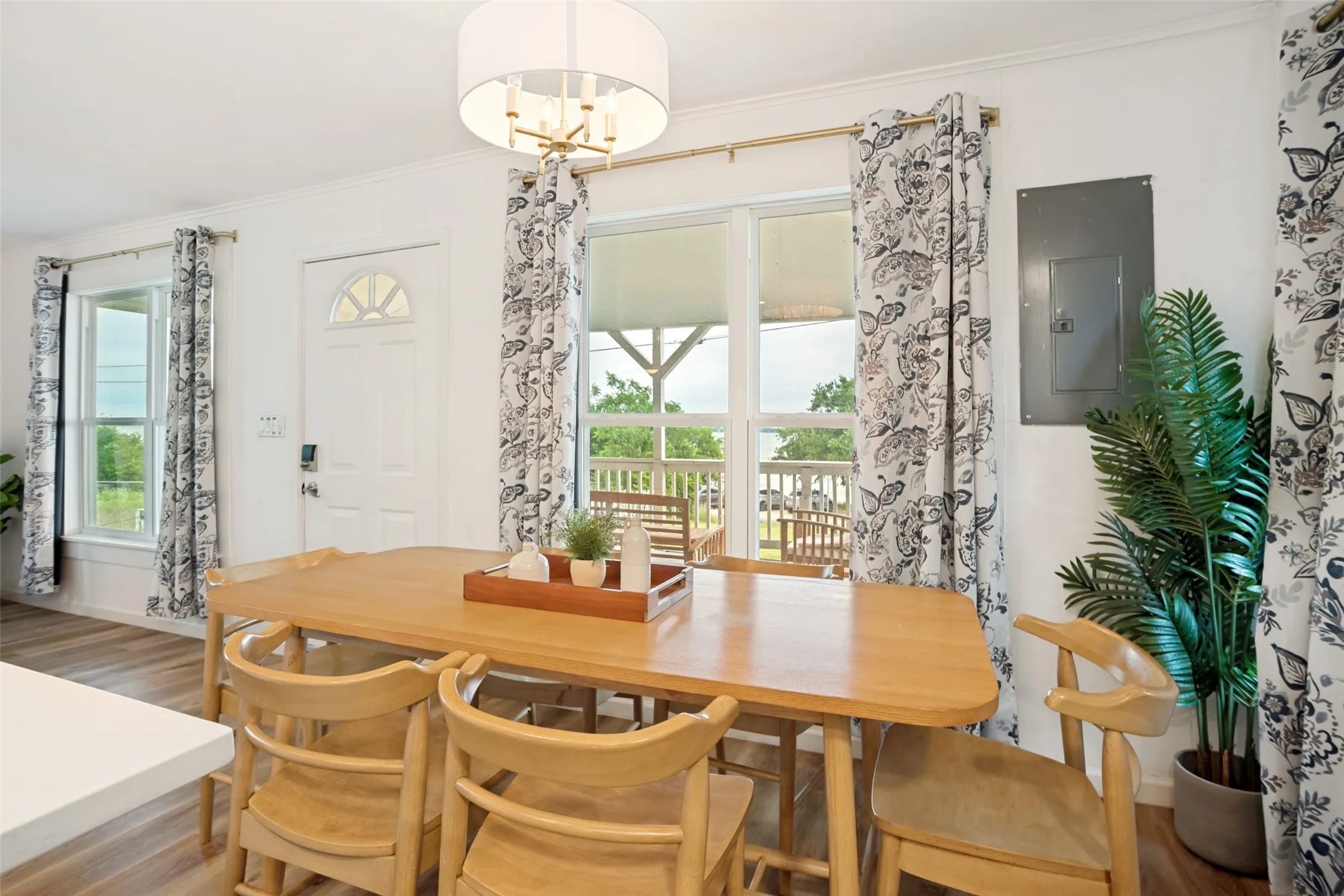 Dining area featuring wood-finish flooring, white walls, and a modern drum pendant light fixture